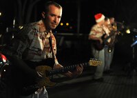 Senior Airman Aaron Kusterer, guitarist with the Hana Hou! Rock Band from the Air Force Band of the Pacific, performs a holiday classic song during the 44th Annual Tower Lighting Celebration at Joint Base Pearl Harbor-Hickam, Hawaii, Dec. 6, 2013. The celebration included food and entertainment for all ages, including a visit from Santa, arts and crafts, and live band performances from Hana Hou! Rock Band and singer/ukulele sensation Aidan James. The highlight of the event was the lighting of Freedom Tower by actors Emma Stone and Bill Murray. (U.S. Air Force photo/Staff Sgt. Alex Martinez)