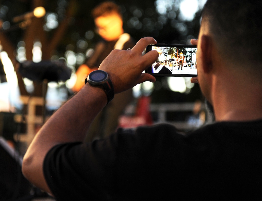 A member of the audience takes a picture of singer/ukulele sensation Aidan James during the 44th Annual Tower Lighting Celebration at Joint Base Pearl Harbor-Hickam, Hawaii, Dec. 6, 2013. The celebration included food and entertainment for all ages, including a visit from Santa, arts and crafts, and live band performances from the Hana Hou! Rock Band from the Air Force Band of the Pacific and James. The highlight of the event was the lighting of Freedom Tower by actors Emma Stone and Bill Murray. (U.S. Air Force photo/Staff Sgt. Alex Martinez)