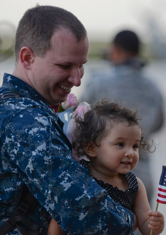 U.S. Navy Petty Officer 1st Class Thomas Ridgway, Helicopter Sea Combat Squadron 25 Detachment 6 aircraft electronics technician, holds his daughter during the HSC-25 Det. 6 homecoming Dec. 9, 2013, on Andersen Air Force Base, Guam. During the unit’s nine-month deployment aboard USS Bonhomme Richard, Det. 6 supported the U.S. Navy 7th Fleet in the Western Pacific area of responsibility. (U.S. Air Force photo by Senior Airman Marianique Santos/Released)