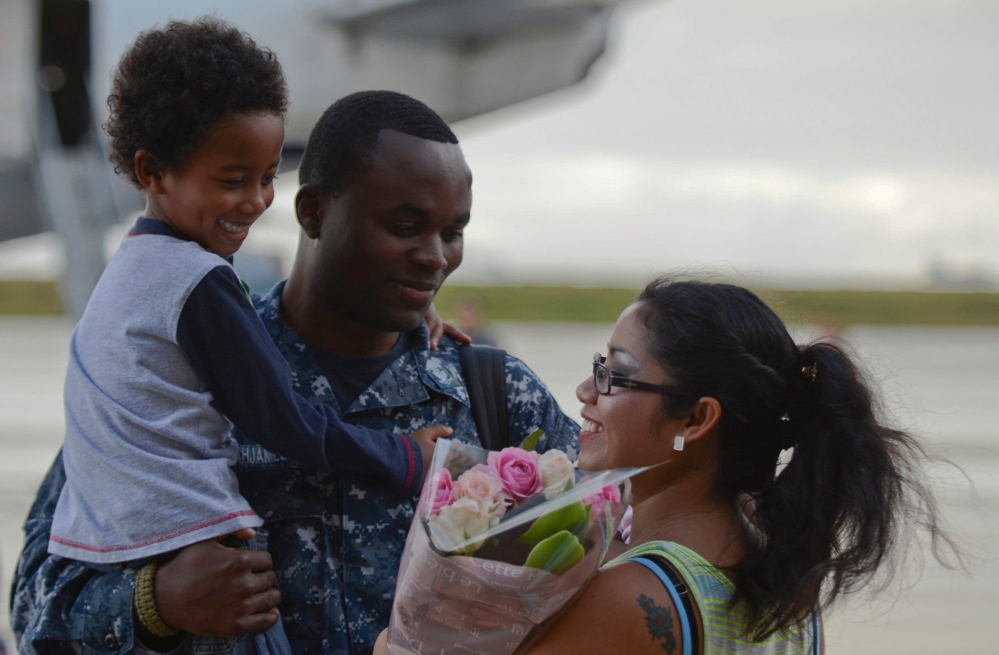 U.S. Navy Petty Officer 2nd Class Jerome Acquajameson, Helicopter Sea Combat Squadron 25 Detachment 6 aviation ordnanceman, embraces his family during the HSC-25 Det. 6 homecoming Dec. 9, 2013, on Andersen Air Force Base, Guam. During the unit’s nine-month deployment aboard USS Bonhomme Richard, Det. 6 supported the U.S. Navy 7th Fleet in the Western Pacific area of responsibility. (U.S. Air Force photo by Senior Airman Marianique Santos/Released)