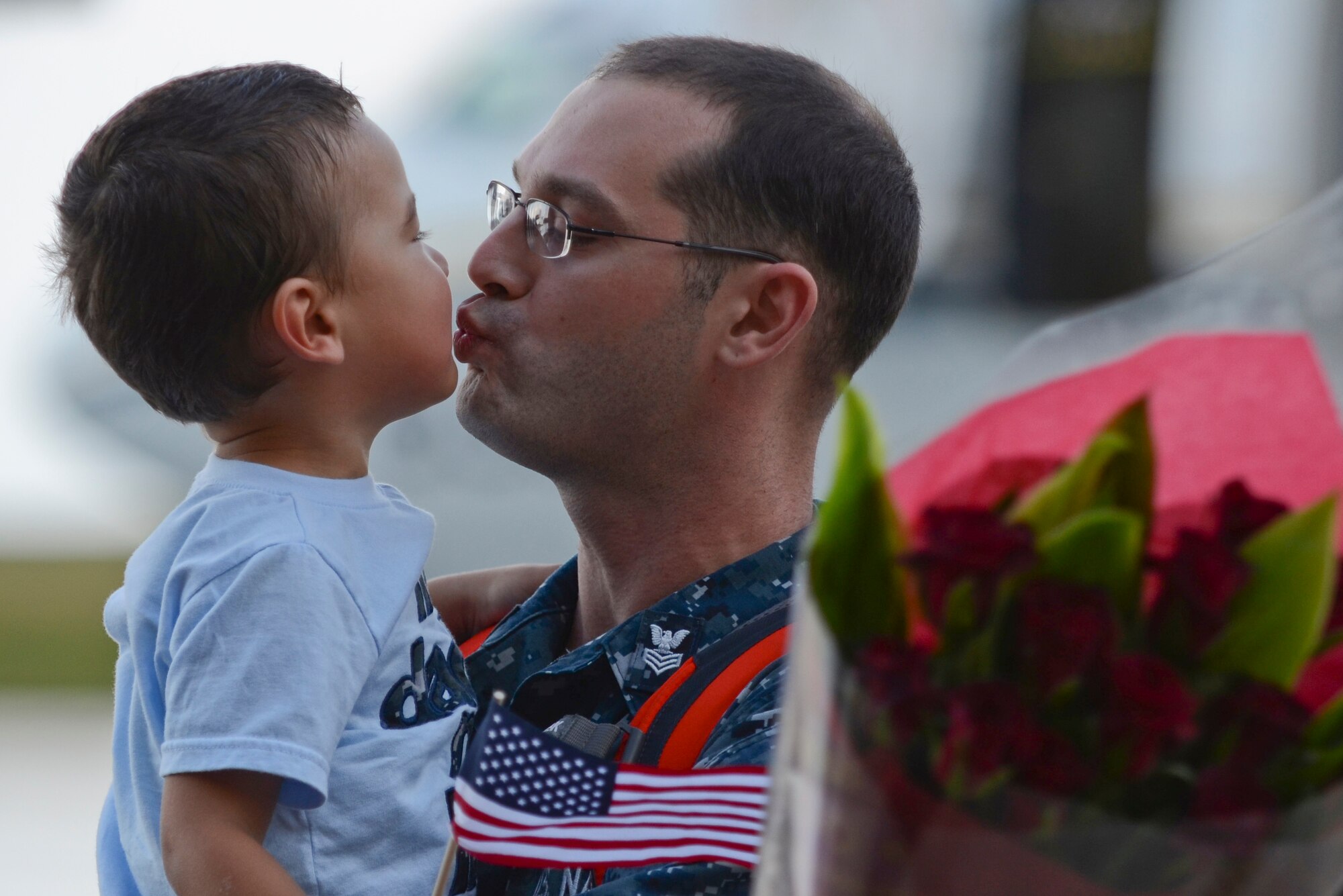 U.S. Navy Petty Officer 1st Class Kevin Norris, Helicopter Sea Combat Squadron 25 Detachment 6 aviation electrician, kisses his son during the HSC-25 Det. 6 homecoming Dec. 9, 2013, on Andersen Air Force Base, Guam. During the unit’s nine-month deployment aboard USS Bonhomme Richard, Det. 6 supported the U.S. Navy 7th Fleet in the Western Pacific area of responsibility. (U.S. Air Force photo by Senior Airman Marianique Santos/Released)