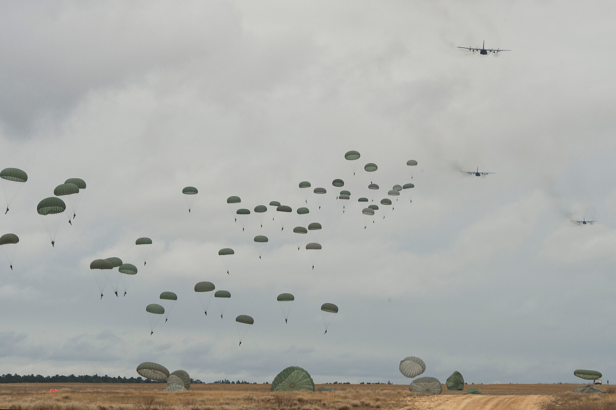 U.S. Army paratroopers float to the ground after successfully jumping from a U.S. Air Force C-130H Hercules in support of Operation Toy Drop, Fort Bragg, N.C., Dec. 7, 2013. The 16th Annual Randy Oler Operation Toy Drop, hosted by the U.S. army Civil Affairs and Psychological Operations Command (Airborne), is the largest combined airborne operation in the world where Fort Bragg's paratroopers and allied jumpmasters donate toys to be distributed to children's homes and social service agencies across the local community. (U.S. Air Force photo/Airman 1st Class Logan Brandt)