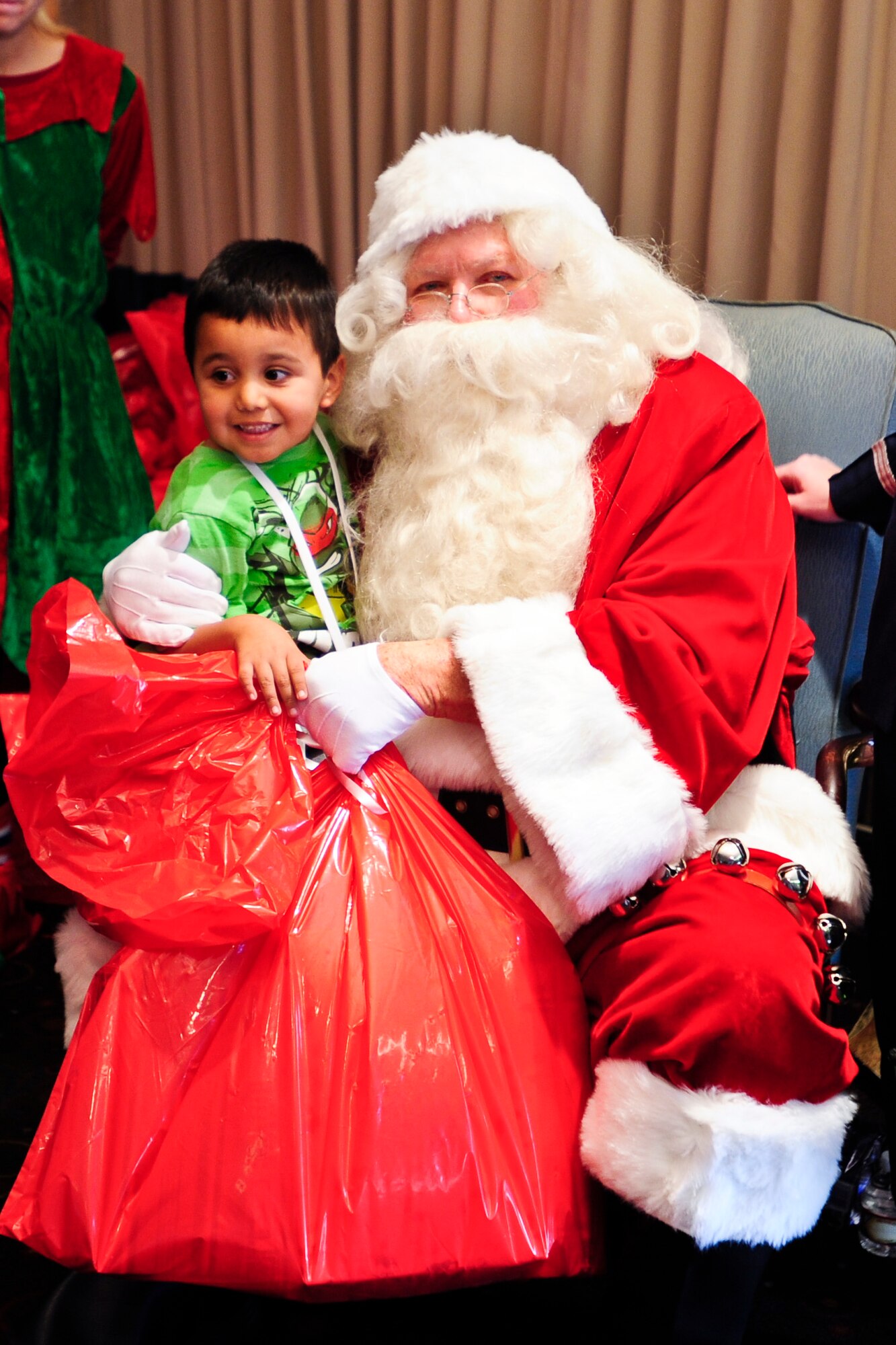 VANDENBERG AIR FORCE BASE, Calif. – A local youth receives a bag of presents from Santa Clause during the Operation Kids Christmas event at the Pacific Coast Club here Saturday, Dec. 7, 2013. OKC is an annual event, organized and run by a private organization, in which about 200 local children are brought on base and given the opportunity to play games, meet Santa and enjoy the companionship of volunteer military members. (U.S. Air Force photo/ Airman 1st Class Yvonne Morales)