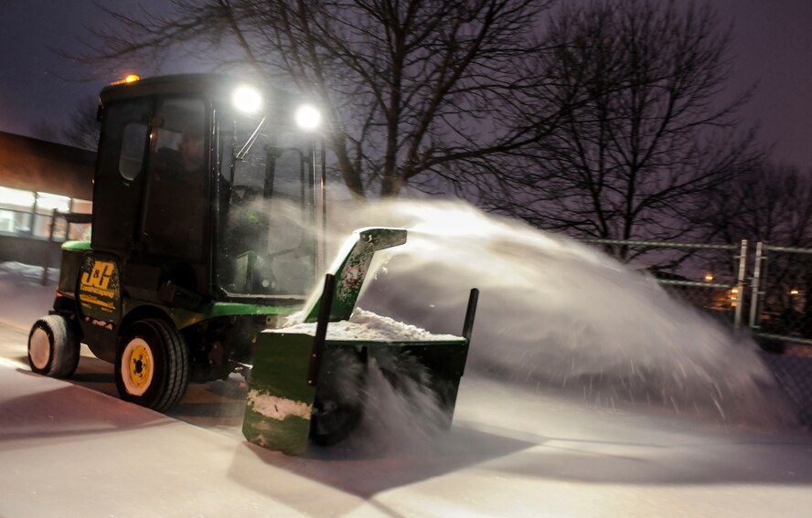 A plume of snow cascades from the top of a snow plow at Minot Air Force Base, N.D., Dec. 3. Small, one person snow plows, such as this are commonly operated by base contractors and are used to clear snow from sidewalks and paths. (U.S. Air Force photo/Senior Airman Stephanie Sauberan)