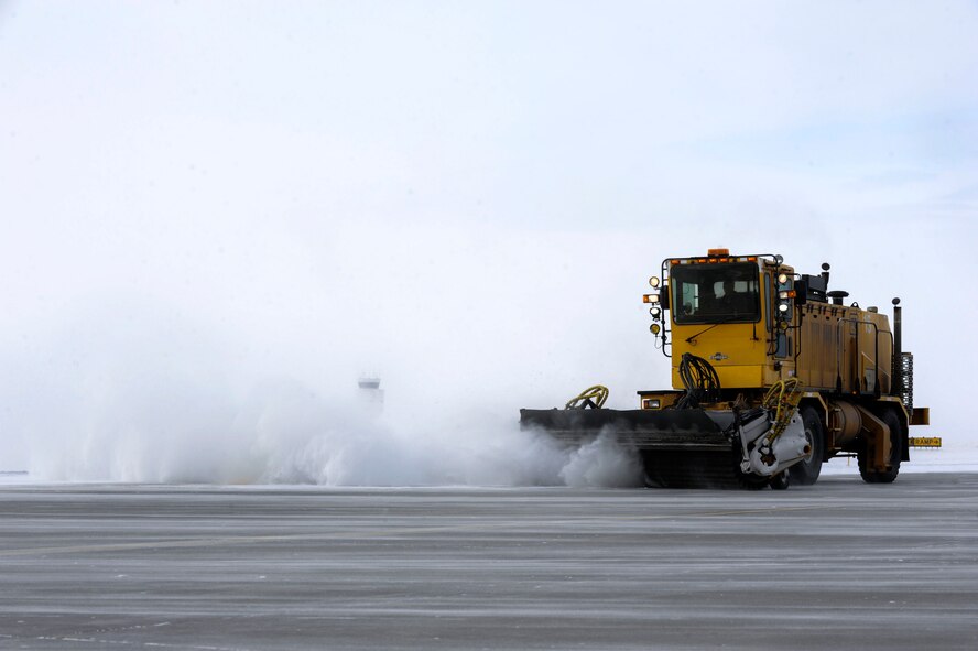 A large sweeper clears snow from the runway at Minot Air Force Base, N.D., Dec. 3. Sweepers, plows and a variety of other heavy equipment keep the runway operating and allow for mission accomplishment, even in the event of blizzards and ice storms. (U.S. Air Force photo/Senior Airman Stephanie Sauberan)