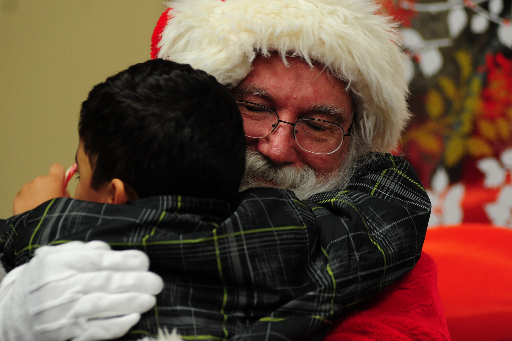 Ari, son of U.S. Air Force Tech. Sgt. Angela, 45th Intelligence Squadron intelligence analyst, hugs Santa Claus during the Exceptional Family Member Program's meet and greet at the Airman and Family Readiness Center Langley Air Force Base, Va., Dec. 6, 2013. During the event, children enjoyed snacks and posed for photos with Santa.  (U.S. Air Force photo by Airman Areca T. Wilson/Released) (Last name withheld for security reasons)