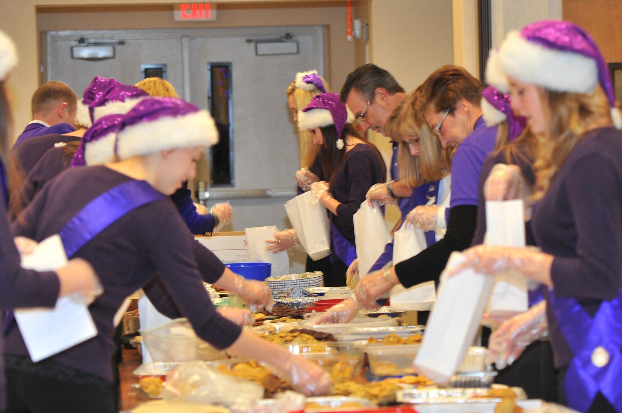 The Spokane Lilac Princesses fill cookie bags for dorm residents for the cookie drive Dec. 9, 2013 at Fairchild Air Force Base, Wash. The cookie drive is an annual event hosted by the Officers’ Spouses Club with help from the chapel staff and the Lilac Princesses. (U.S. Air Force photo by Staff Sgt. Veronica Montes/Released)