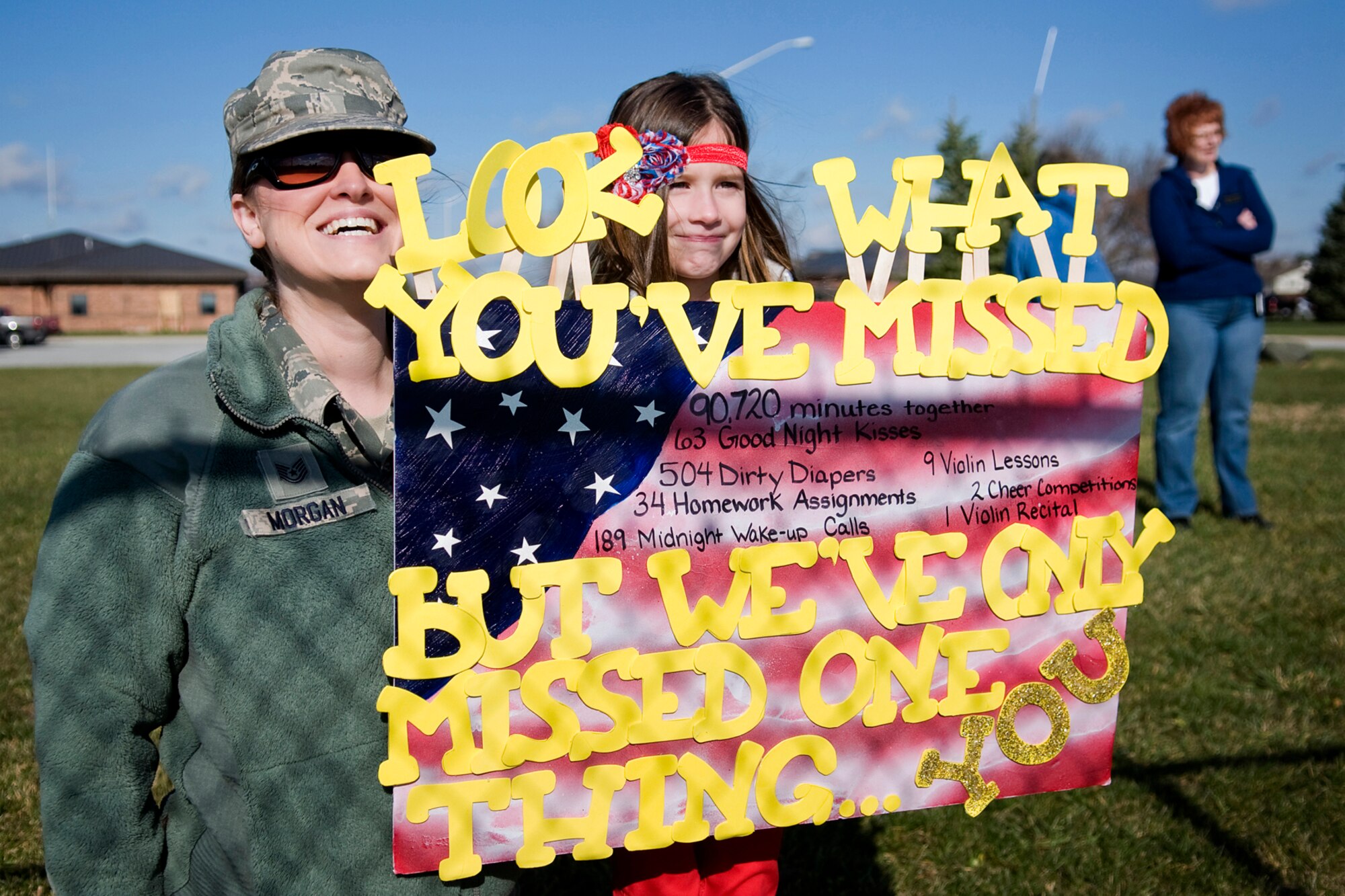 Tech. Sgt. Erica Morgan, 434th Aircraft Maintenance Squadron personnel specialist, and her 7-year-old daughter, Melea, brave the cold to welcome home Master Sgt. Michael Morgan, 72nd Air Refueling Squadron inflight refueling evaluator, as he returns to Grissom Air Reserve Base, Ind., after a deployment to Southwest Asia Nov. 18, 2013. Family and friends gathered at the base, some with homemade signs, to welcome back their loved ones. (U.S. Air Force photo/Tech. Sgt. Mark R. W. Orders-Woempner)
