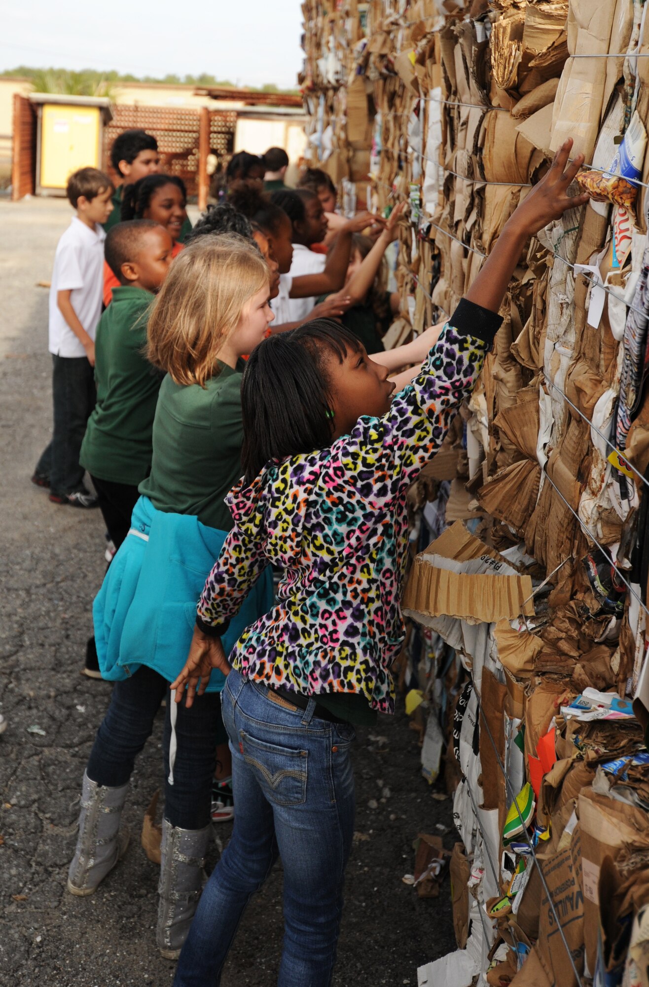 Students from Springfield Elementary School touch bundles of bound cardboard during a visit to Tyndall Dec. 5 at the Recycling Center on base. This was part of a 325th Civil Engineer Squadron program that teaches environmental information to local schools. (U.S. Air Force photo by Airman 1st Class Alex Echols)