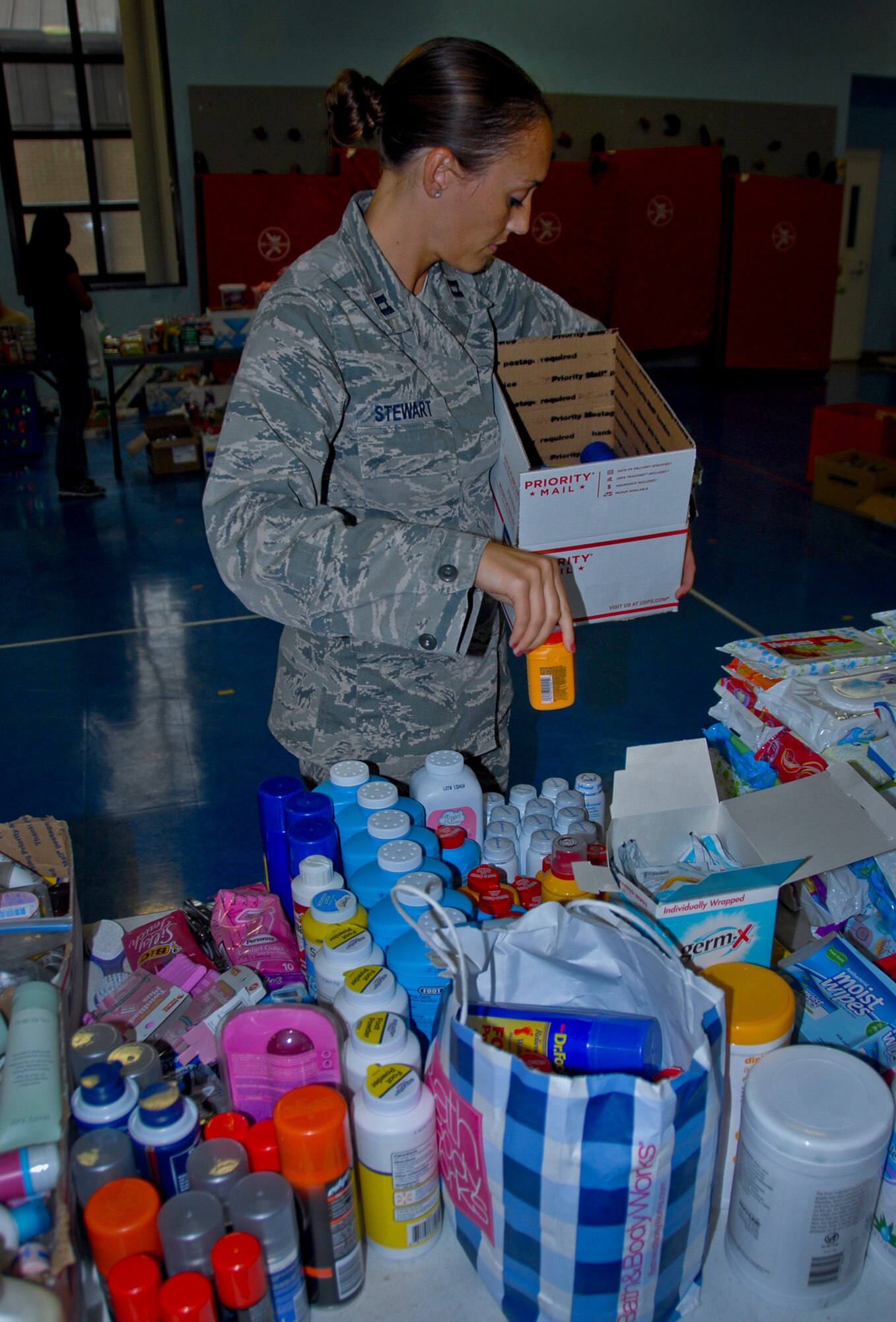 Capt. Corrine Stewart, of the 96th Medical Group, loads donated health and comfort items into to a Christmas care package, at the troop care drive, at the Eglin Elementary School gym Dec. 5. The Company Grade Officers’ Council collected more than 6,000 items and more than 1,000 handwritten Christmas cards from 12 Okaloosa County schools, area agencies and base squadrons for the packages.  Volunteers, spouses and families of Eglin’s deployed troops assisted in putting together 183 care packages for shipment overseas. The total shipment weighed 926 lbs.  (U.S. Air Force photo/Kevin Gaddie)
