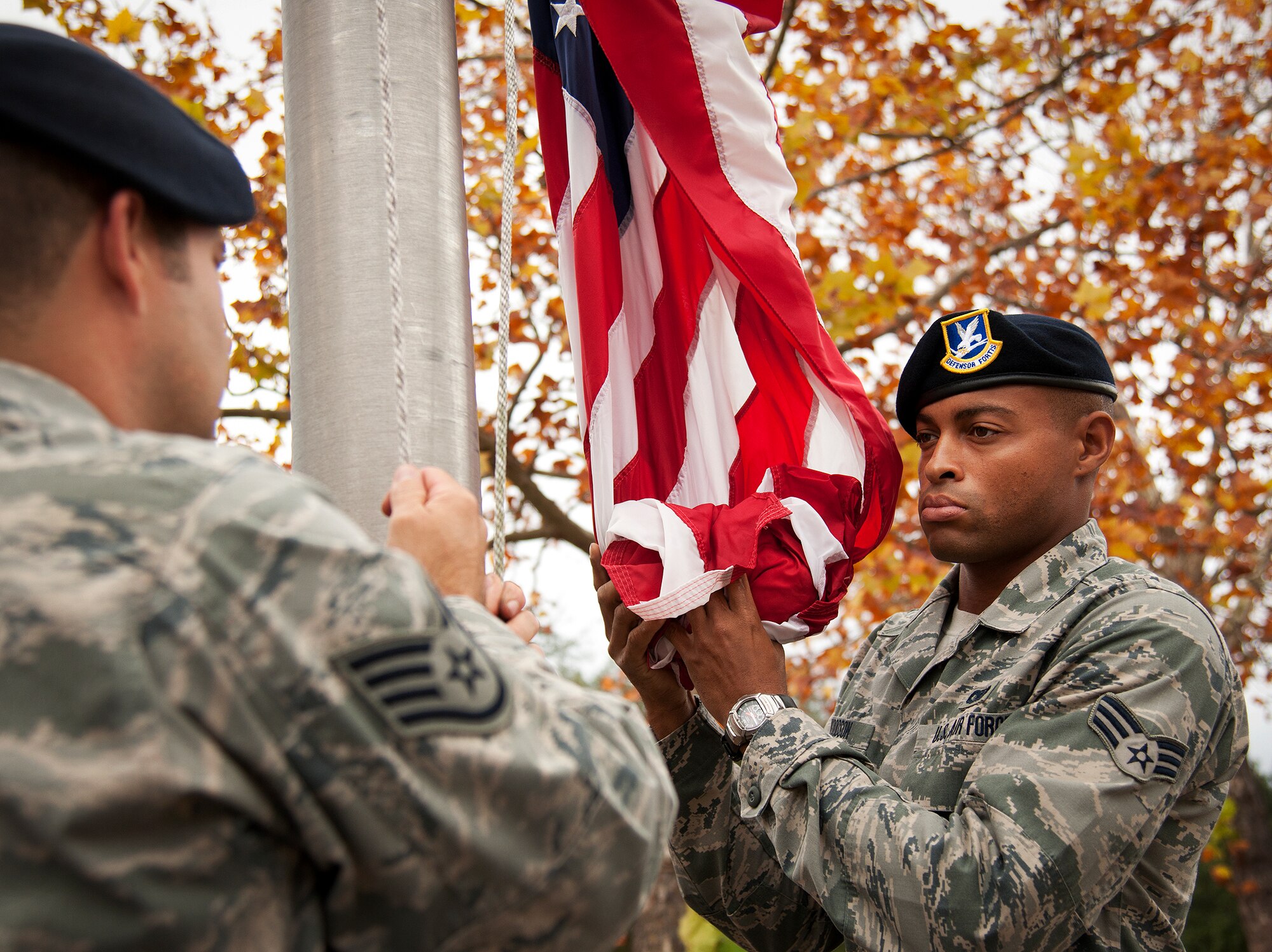 Senior Airman Kendrick Woodson secures the American Flag as it is lifted up at the 919th Special Operations Wing headquarters building at Duke Field, Fla., Dec. 6.  Woodson and other 919th Security Forces Squadron members fulfilled a request from a retiring former 919th SOW member to have a flag flown at the base.  The flag was flown above the headquarters building for a few seconds while security forces members saluted before being brought down and folded for presentation.  (U.S. Air Force photo/Tech. Sgt. Sam King)
