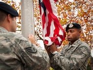 Senior Airman Kendrick Woodson secures the American Flag as it is lifted up at the 919th Special Operations Wing headquarters building at Duke Field, Fla., Dec. 6.  Woodson and other 919th Security Forces Squadron members fulfilled a request from a retiring former 919th SOW member to have a flag flown at the base.  The flag was flown above the headquarters building for a few seconds while security forces members saluted before being brought down and folded for presentation.  (U.S. Air Force photo/Tech. Sgt. Sam King)