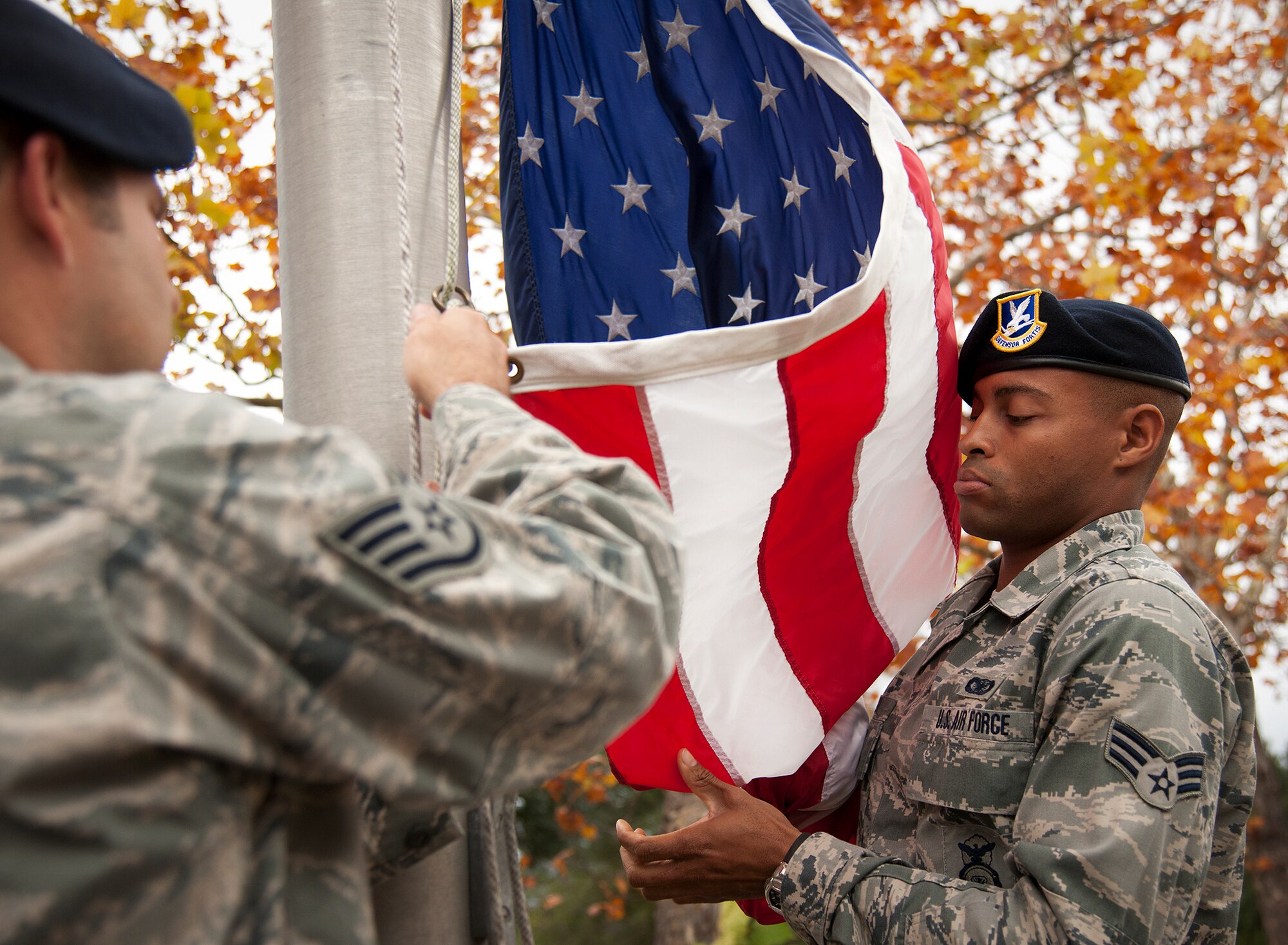 Senior Airman Kendrick Woodson secures the American Flag as it is lifted up at the 919th Special Operations Wing headquarters building at Duke Field, Fla., Dec. 6.  Woodson and other 919th Security Forces Squadron members fulfilled a request from a retiring former 919th SOW member to have a flag flown at the base.  The flag was flown above the headquarters building for a few seconds while security forces members saluted before being brought down and folded for presentation.  (U.S. Air Force photo/Tech. Sgt. Sam King)