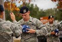 Staff Sgt. Josiah Wood brings in a new flag to be flown above the 919th Special Operations Wing headquarters building at Duke Field, Fla., Dec. 6.  Wood and other 919th Security Forces Squadron members fulfilled a request from a retiring former 919th SOW member to have a flag flown at the base.  The flag was flown above the headquarters building for a few seconds while security forces members saluted before being brought down and folded for presentation.  (U.S. Air Force photo/Tech. Sgt. Sam King)