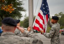 Tech. Sgt. Bryan Poole salutes as the American Flag is brought down in front of the 919th Special Operations Wing headquarters building at Duke Field, Fla., Dec. 6.  Poole and other 919th Security Forces Squadron members fulfilled a request from a retiring former 919th SOW member to have a flag flown at the base.  The flag was flown above the headquarters building for a few seconds while security forces members saluted before being brought down and folded for presentation.  (U.S. Air Force photo/Tech. Sgt. Sam King)