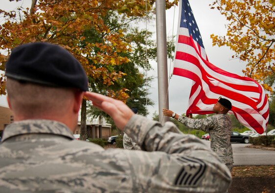 Tech. Sgt. Bryan Poole salutes as the American Flag is brought down in front of the 919th Special Operations Wing headquarters building at Duke Field, Fla., Dec. 6.  Poole and other 919th Security Forces Squadron members fulfilled a request from a retiring former 919th SOW member to have a flag flown at the base.  The flag was flown above the headquarters building for a few seconds while security forces members saluted before being brought down and folded for presentation.  (U.S. Air Force photo/Tech. Sgt. Sam King)