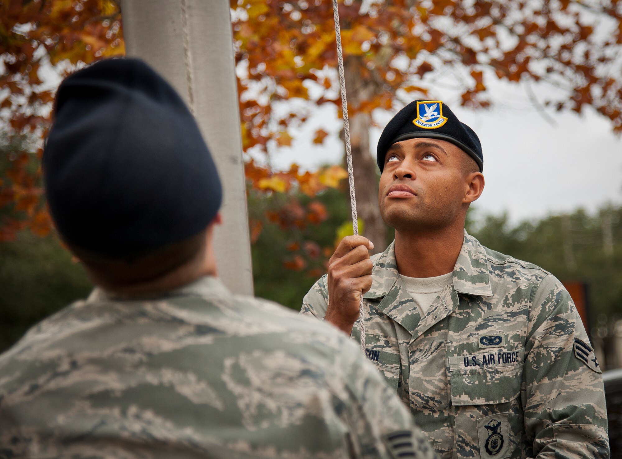 Senior Airman Kendrick Woodson brings down the American Flag flown at the 919th Special Operations Wing headquarters building at Duke Field, Fla., Dec. 6.  Woodson and other 919th Security Forces Squadron members fulfilled a request from a retiring former 919th SOW member to have a flag flown at the base.  The flag was flown above the headquarters building for a few seconds while security forces members saluted before being brought down and folded for presentation.  (U.S. Air Force photo/Tech. Sgt. Sam King)