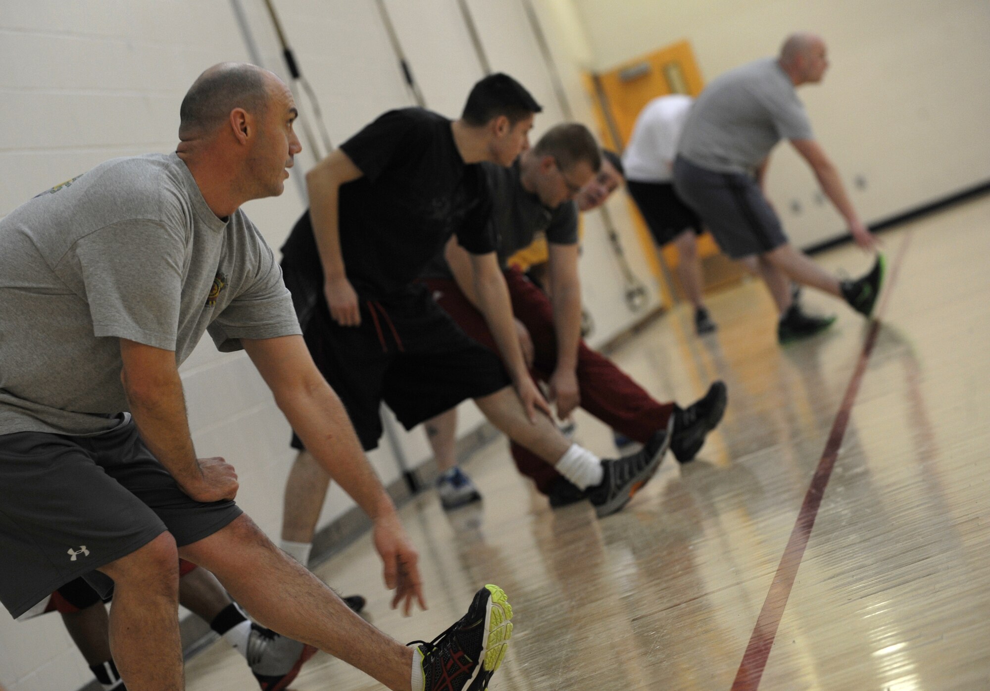 Airmen from of the 372nd Training Squadron at Minot Air Force Base, among others, take part in a stretching exercise during a Fit to Fight physical fitness class, Dec. 6. The McAdoo Sports and Fitness Center offers a variety of physical fitness classes for both Airmen and dependants to take part in. (U.S. Air Force photo/Senior Airman Jose L. Hernandez)