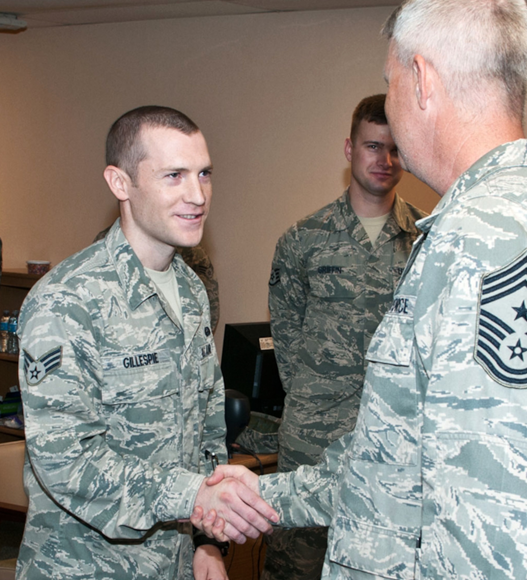 Senior Airman Evan Gillespie, left, is congratulated by Chief Master Sgt. Mark Aman, the 71st Flying Training Wing command chief, for selection as Wing Airman of the Month for October. Gillespie is an airfield systems technician with the 71st Communications Squadron at Vance Air Force Base, Okla. (U.S. Air Force photo/ Terry Wasson)