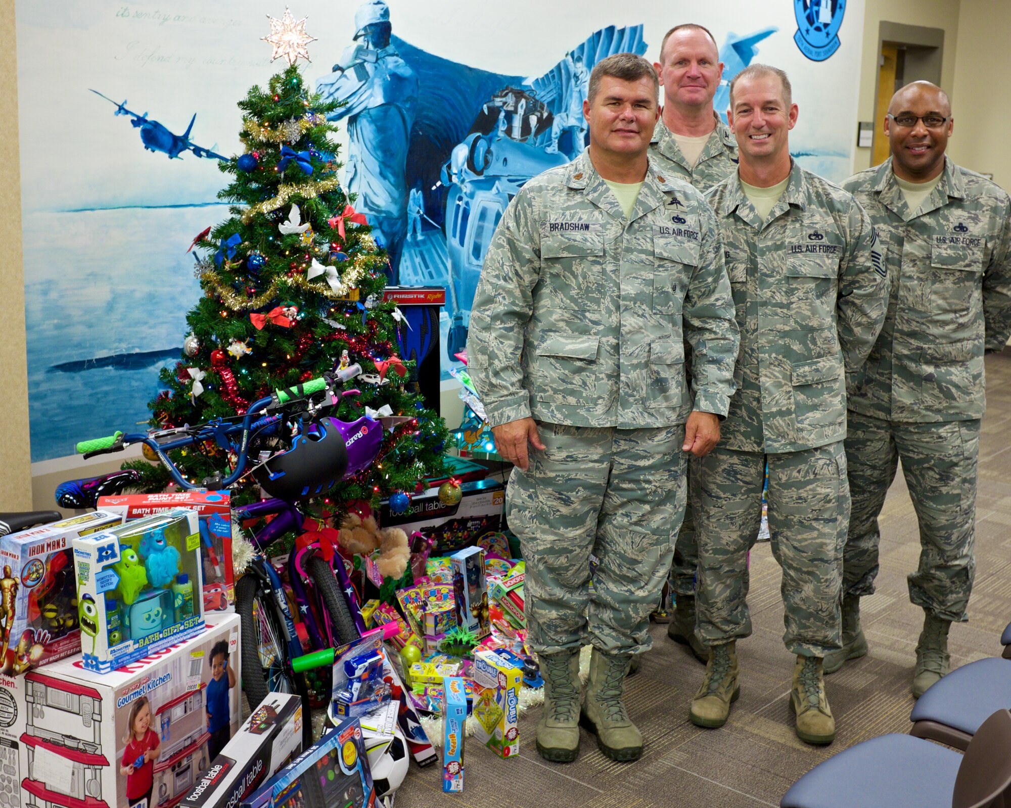 Maj. Rusty Bradshaw, 70th Aerial Port Squadron commander, Col. Chris Funk, Homestead Air Reserve Base Commander, Chief Master Sgt. Frederick Becking, Operations Chief for the 70th APS, and  Chief Master Sgt. Katdo Robinson,  HARB Command Chief, stand next to the 70th APS tree during the Christmas Tree Challenge judging on Dec. 8. They took 3rd place in the challenge.