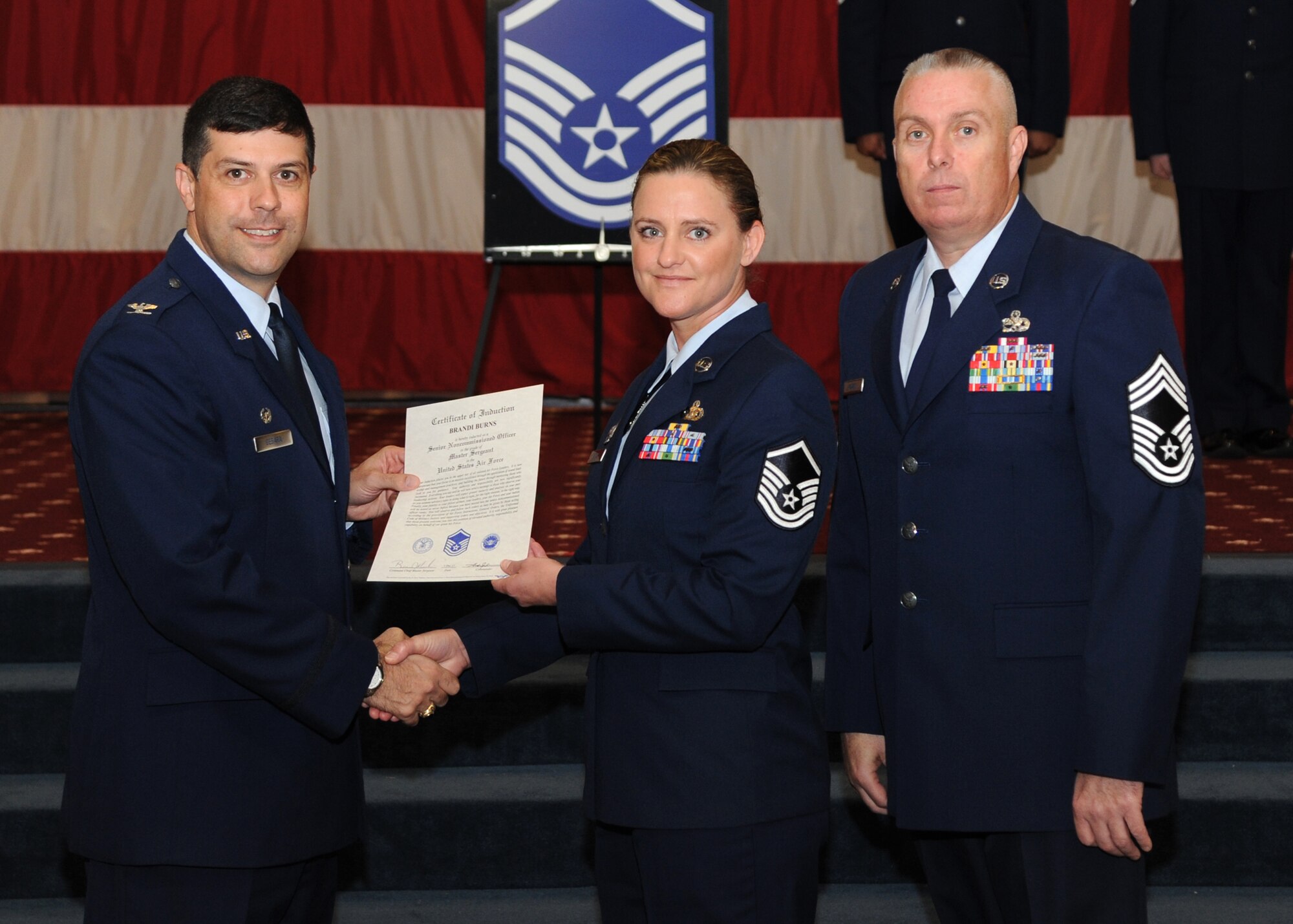 Master Sgt. Brandi Burns, 2nd Security Forces Squadron, receives a certificate of promotion from Col. Andrew Gebara, 2nd Bomb Wing commander, and Chief Master Sgt. Beau Markin, 2nd Maintenance Group, during the November Wing Promotion Ceremony on Barksdale Air Force Base, La., Nov. 27, 2013. Burns was selected from 1,000 NCOs across the Air Force to become a first sergeant. (U.S. Air Force photo/Senior Airman Joseph A. Pagán Jr.)