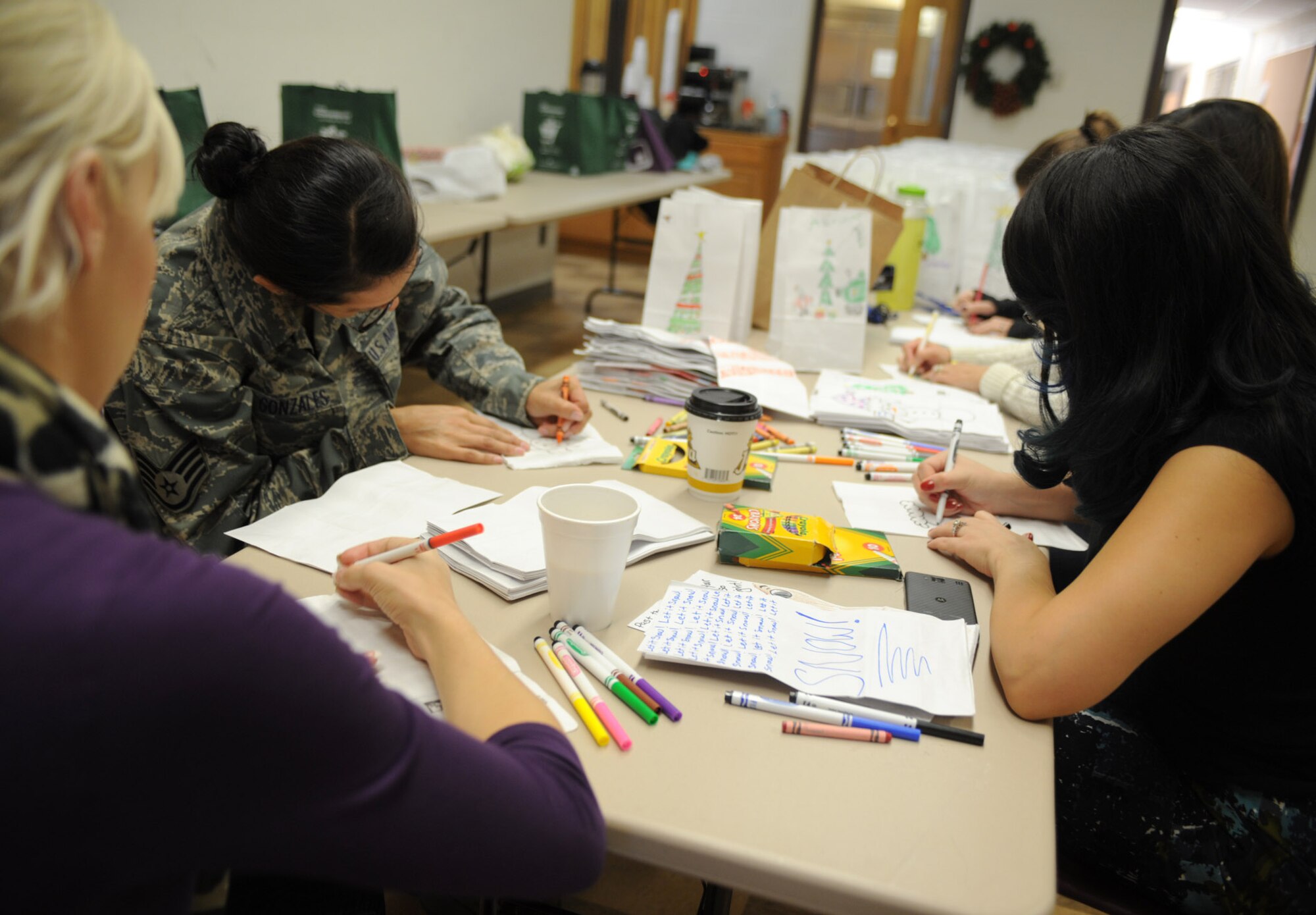 Volunteers decorate goodie bags as part of Operation Cookie Drop Dec. 6, 2013, at Cannon Air Force Base, N.M. Operation Cookie Drop provides cookies to dormitory Airmen every year during the holiday season. (U.S. Air Force photo/Senior Airman Ericka Engblom)