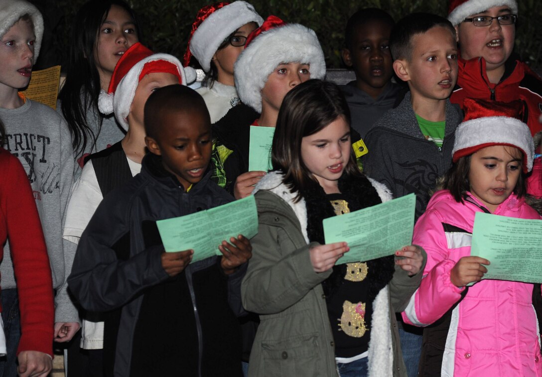 A children choir sings carols during the tree lighting ceremony Dec. 4, 2013, at Cannon Air Force Base, N.M. The parade included floats decorated by the squadrons and an appearance by Santa Claus himself. (U.S. Air Force photo/Airman 1st Class Chip Slack)