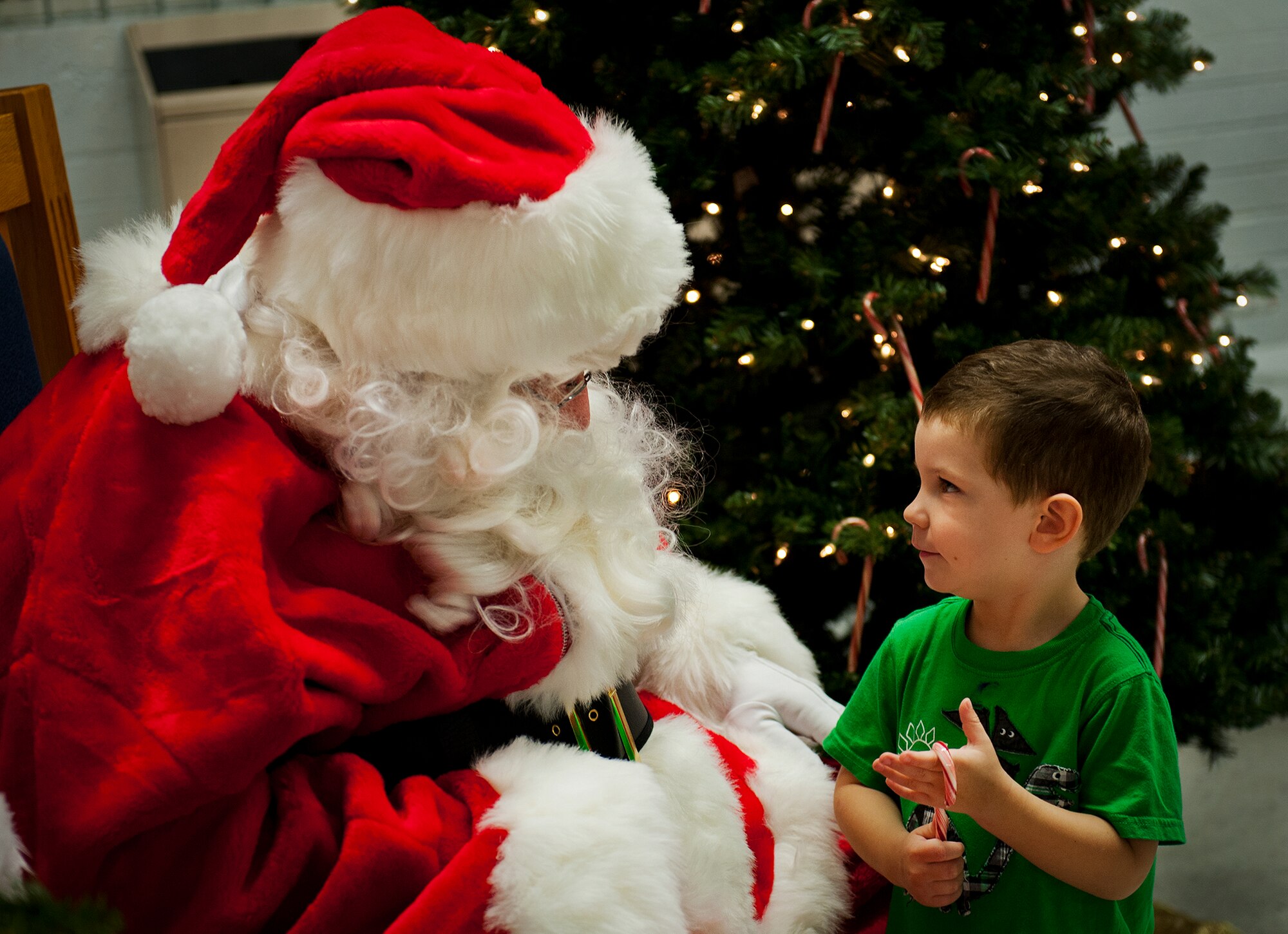 Jack Hudson tells Santa Claus what he would like for Christmas at Team Eglin's annual Christmas tree lighting ceremony at the West Gate Chapel Dec. 6. Chaplains and senior leadership led the event with messages of unity and awards for the base-wide, life-sized card decoration contest. Following the lighting of the tree, Santa arrived by fire truck to meet with the children and hear their Christmas wishes. (U.S. Air Force photo/Sara Vidoni)