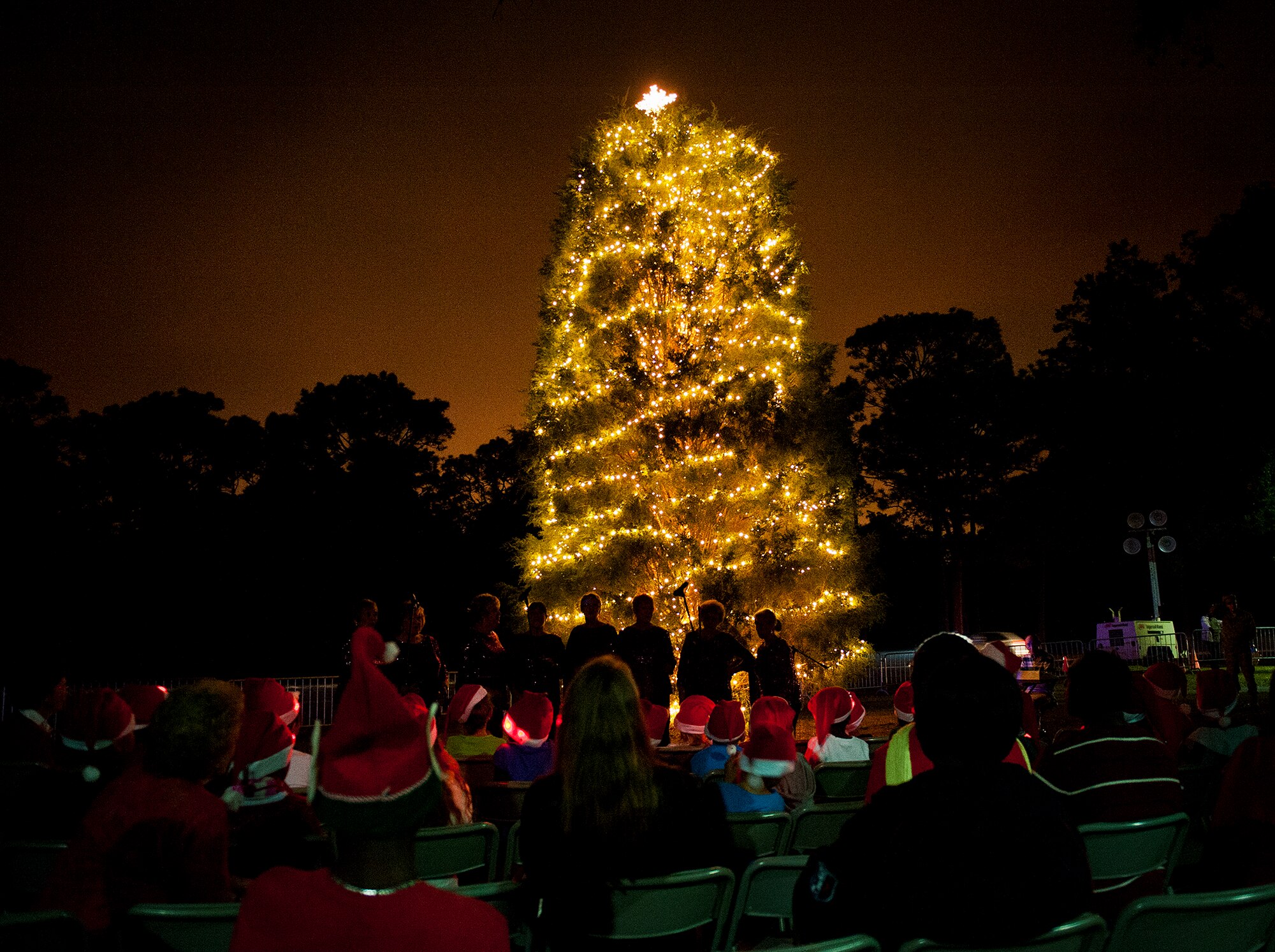 The Sugar Beach quartet entertains the crowd with Christmas carols at Team Eglin's annual Christmas tree lighting ceremony at the West Gate Chapel Dec. 6. Chaplains and senior leadership led the event with messages of unity and awards for the base-wide, life-sized card decoration contest. Following the lighting of the tree, Santa Claus arrived by fire truck to meet with the children and hear their Christmas wishes. (U.S. Air Force photo/Sara Vidoni)