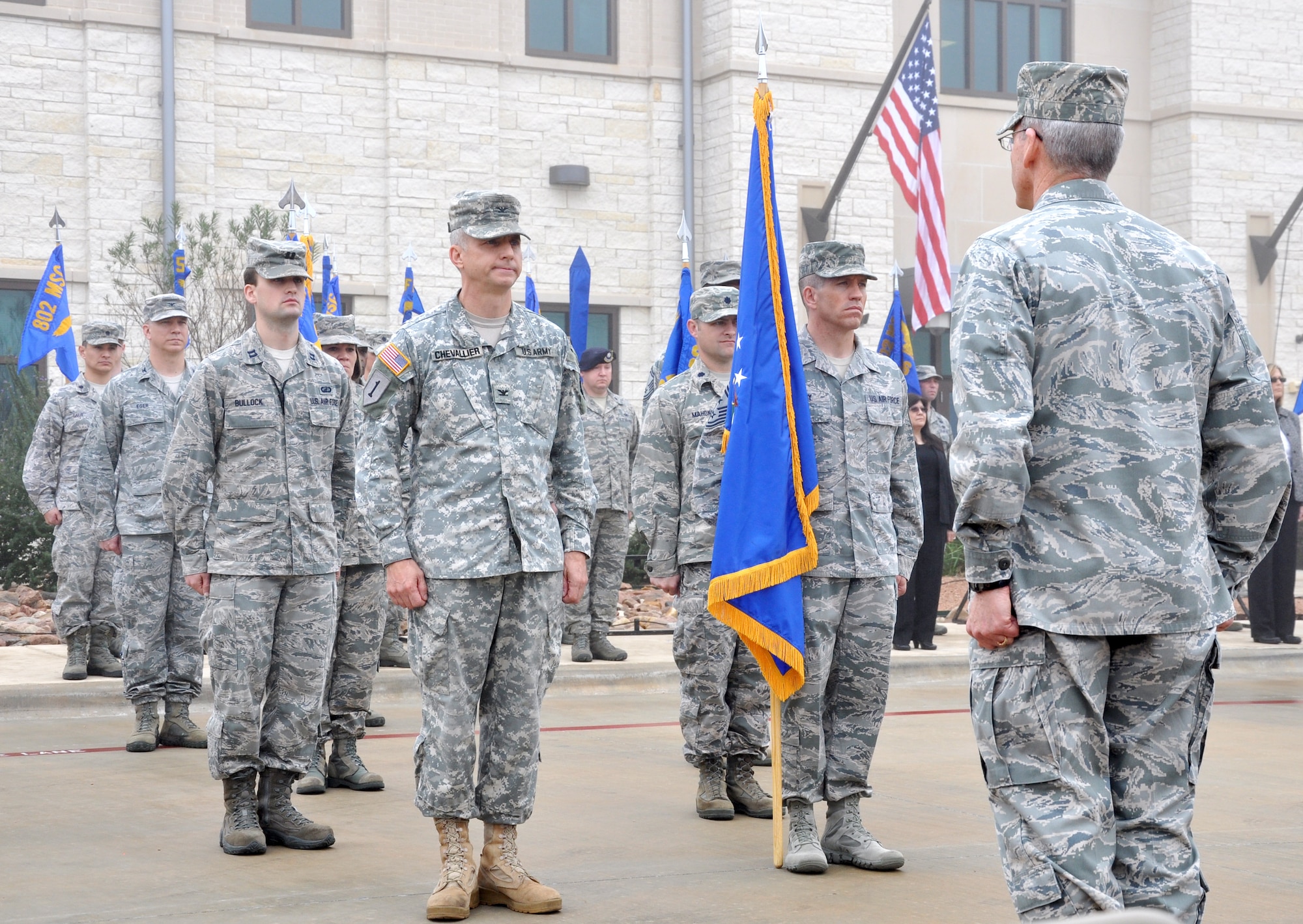 (From right) Brig. Gen. Bob LaBrutta, Joint Base San Antonio and 502nd Air Base Wing commander, receives the wing’s colors from Chief Master Sgt. Alexander Perry,  JBSA/502nd ABW command chief master sergeant; and Army Col. Jim Chevallier, JBSA/502nd ABW vice commander during the 502nd Air Base Wing transformation ceremony at Joint Base San Antonio-Fort Sam Houston Dec. 4. (U.S. Air Force photo by Steve Elliott)