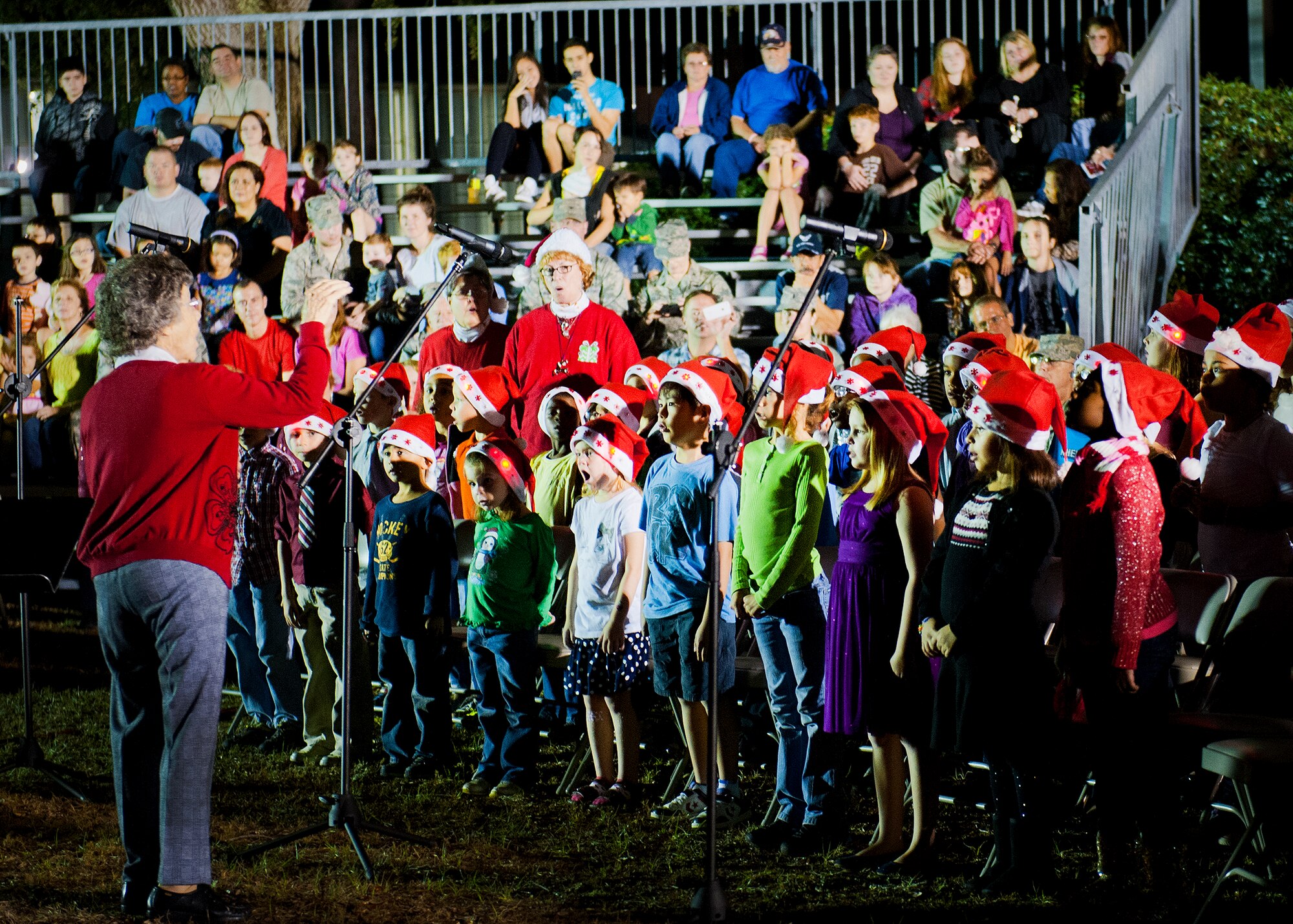 The Chapel and Arts Ministry Program children's choir directed by Audrey Bonanno led the crowd in Christmas carols at Team Eglin's annual Christmas tree lighting ceremony at the West Gate Chapel Dec. 6. Chaplains and senior leadership led the event with messages of unity and awards for the base-wide, life-sized card decoration contest. Following the lighting of the tree, Santa Claus arrived by fire truck to meet with the children and hear their Christmas wishes. (U.S. Air Force photo/Sara Vidoni)