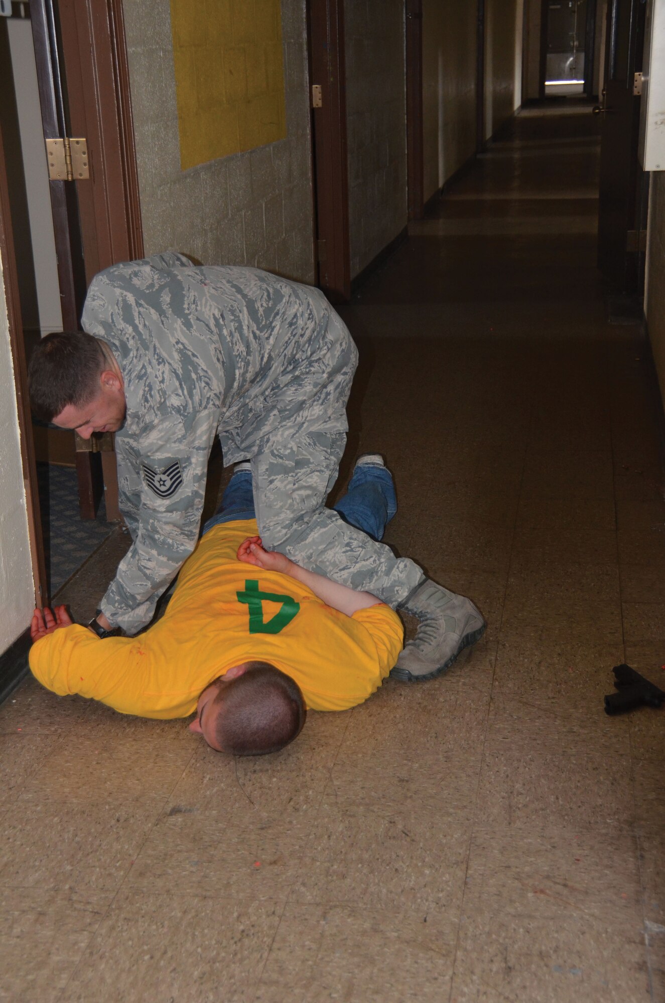 WRIGHT-PATTERSON AIR FORCE BASE, Ohio - Tech. Sgt. Ryan Lause handcuffs the “gunman” at the conclusion of active shooter scenario. Four 445th Security Forces Squadron reservists participated in a multi-agency Solo Engagement Training July 11 at the former Marine Corps Reserve training and administrative center located in Dayton, Ohio. The training was hosted by the Wright State University Police Department. (U.S. Air Force photo/Stacy Vaughn)