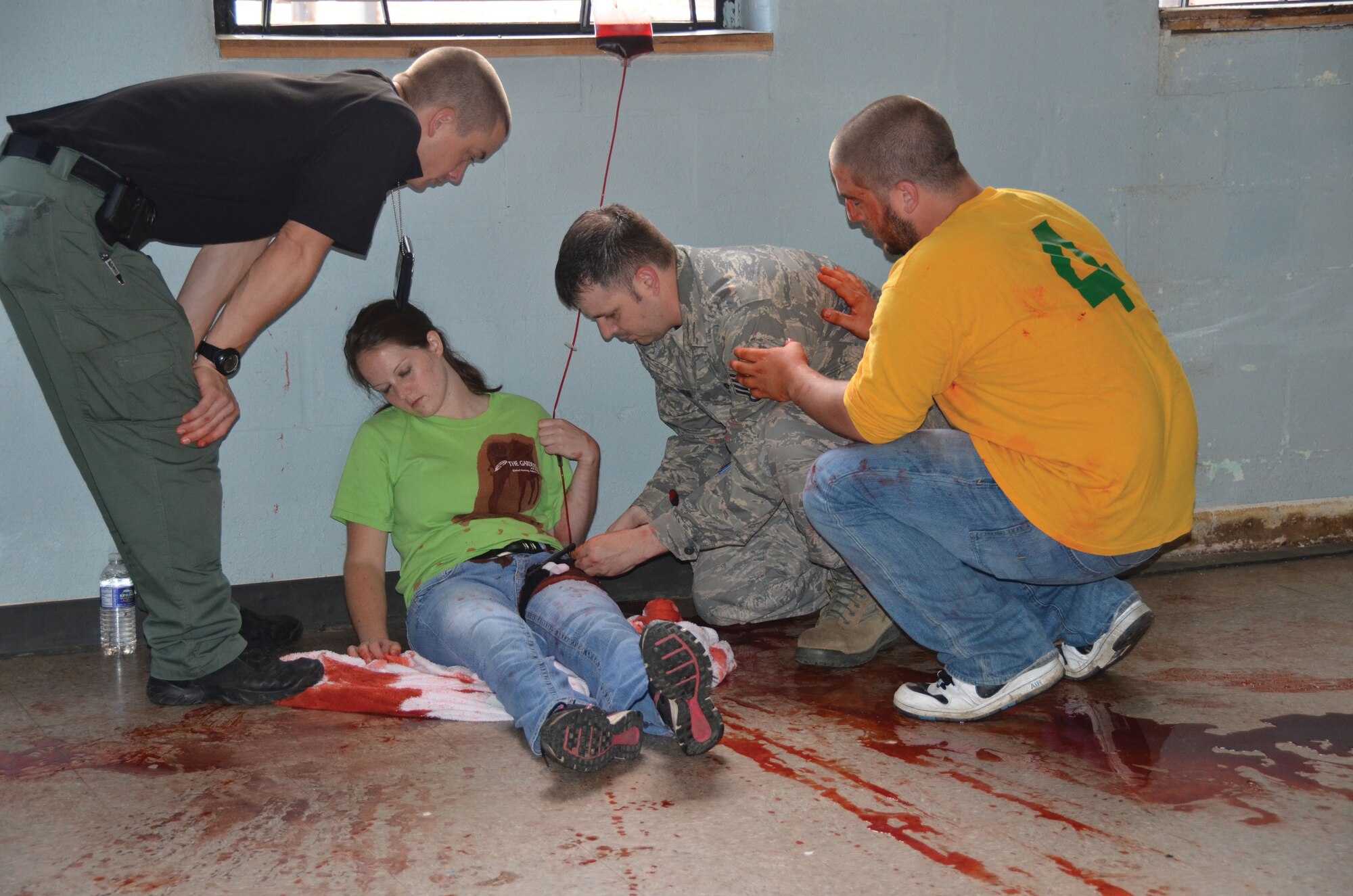 WRIGHT-PATTERSON AIR FORCE BASE, Ohio - Nadi Graham, Ohio State Highway Patrol, instructs Staff Sgt. Bjorn Solheim, 445th Security Forces Squadron how to treat a "shooting victim" with the distraction of the victim's boyfriend during an active shooter scenario July 11, 2013.  Four 445th Security Forces Squadron reservists participated in the multi-agency Solo Engagement Training in Dayton, Ohio. (U.S. Air Force photo/Stacy Vaughn)