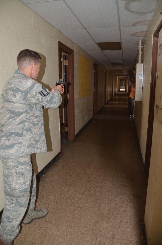 WRIGHT-PATTERSON AIR FORCE BASE, Ohio - Tech. Sgt. Ryan Lause draws his weapon as he asks the "gunman" to surrender during an active shooter scenario July 11.  Four 445th Security Forces Squadron reservists participated in a multi-agency Solo Engagement Training at the former Marine Corps Reserve training and administrative center located in Dayton, Ohio. The training was hosted by the Wright State University Police Department. (U.S. Air Force photo/Stacy Vaughn)