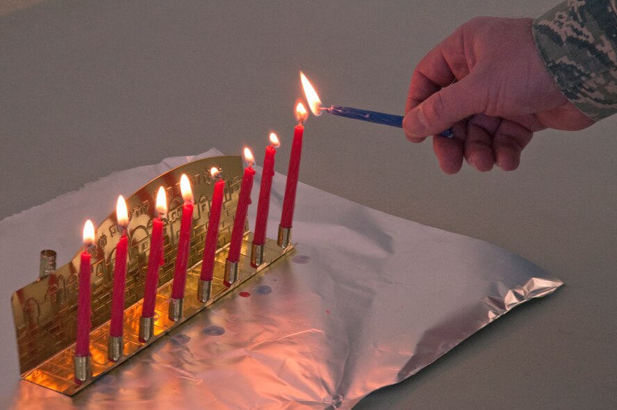 131206-F-GZ967-009 Chaplain (Lt. Col.) Joshua Narrowe, 90th Missile Wing chaplain, lights the final candle of his menorah Dec. 5 during an observance of the last day of Hanukkah. (U.S. Air Force photo by Airman 1st Class Brandon Valle))
