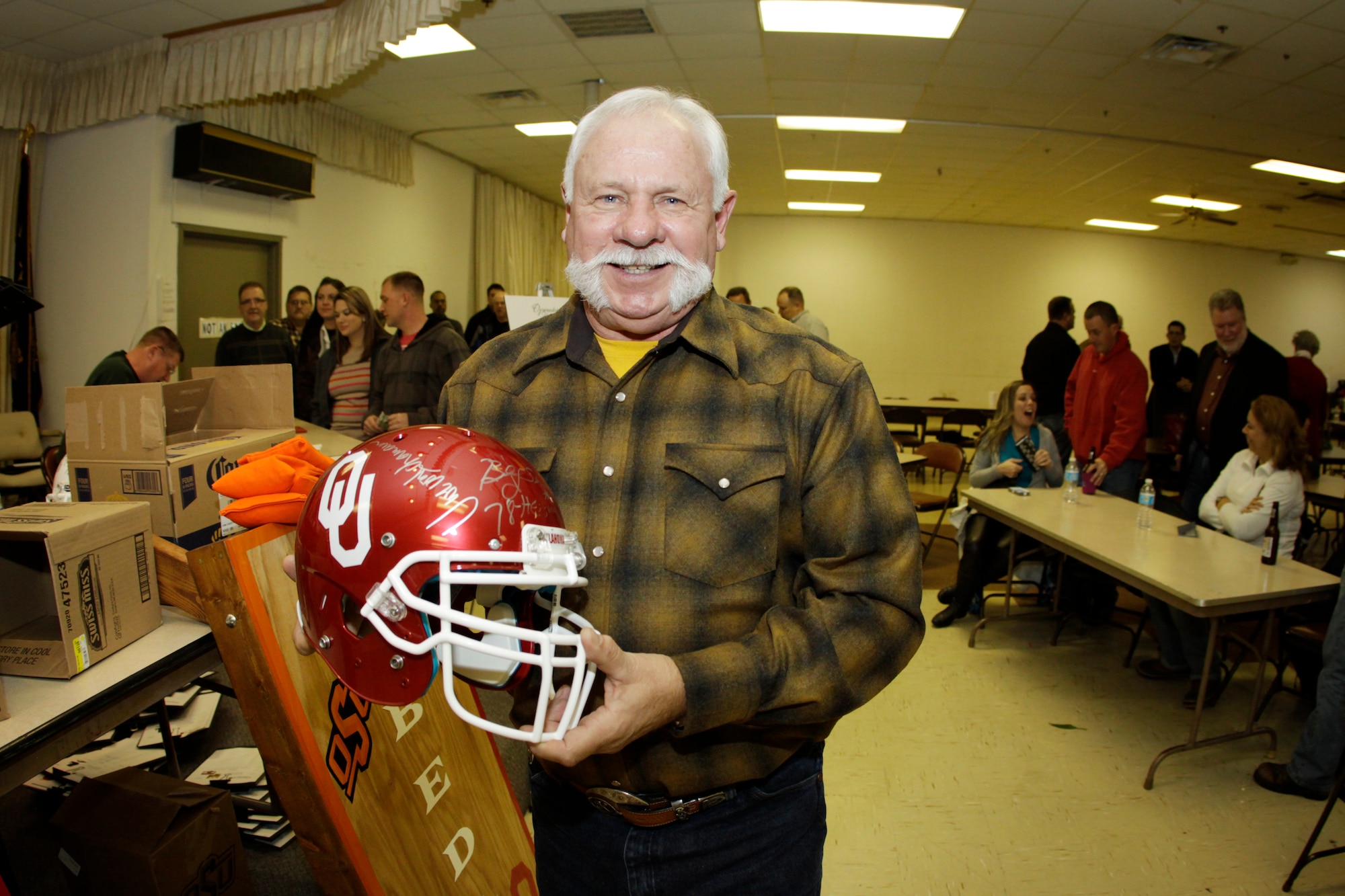 Former 507th Air Refueling Wing Command Chief Bob Kellington shows off his new football helmet during the Operation Holiday Spirit fund-raiser at the Del City American Legion, Dec. 7. (U.S. Air Force Photo/Staff Sgt. Caleb Wanzer) 