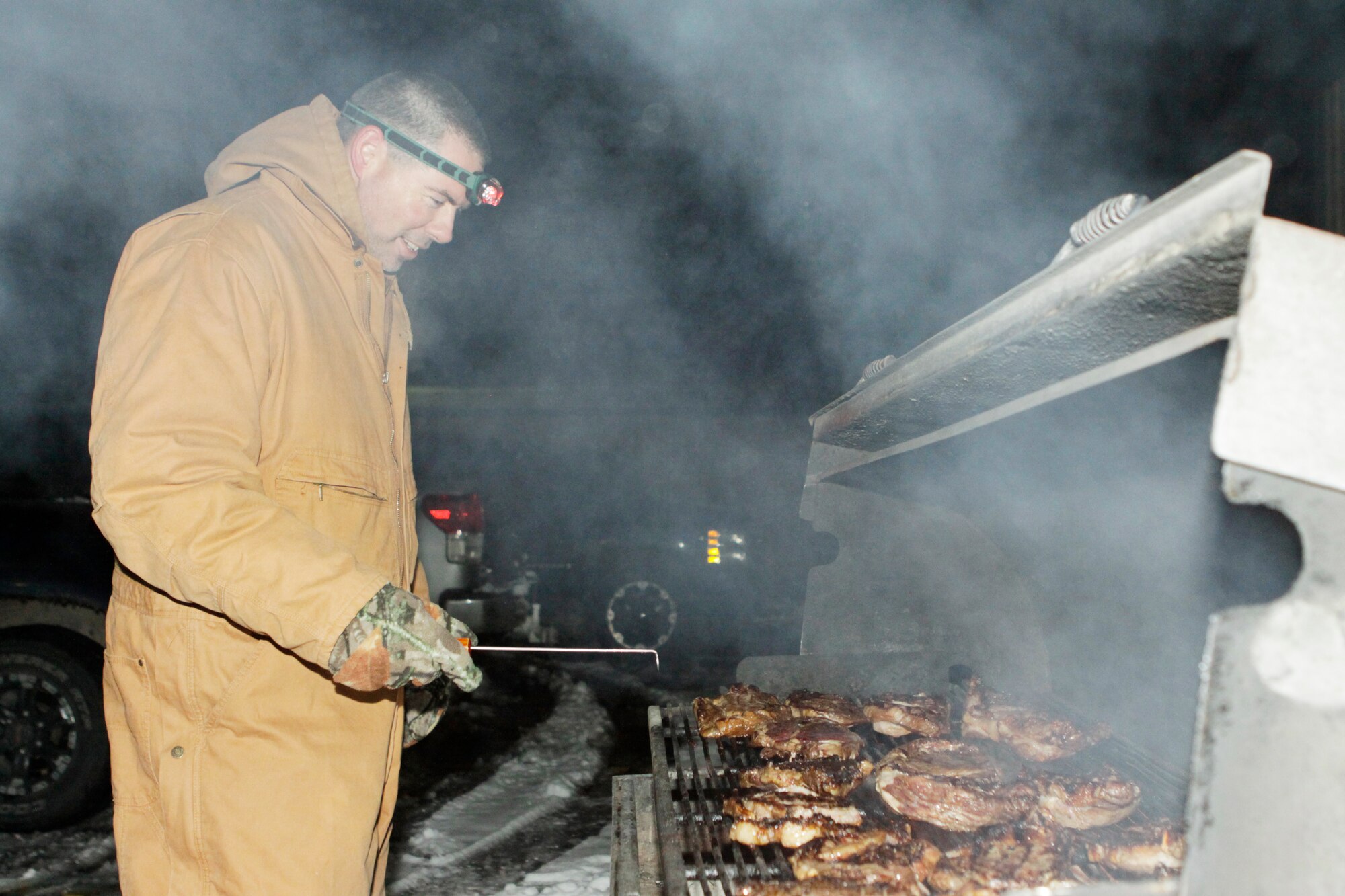 Master Sgt. Frank Deitchman, 513th Air Control Group, watches the rib eyes with a
careful eye as he works to stay warm in the below-freezing temperatures. (U.S. Air Force Photo/Staff Sgt. Caleb Wanzer)