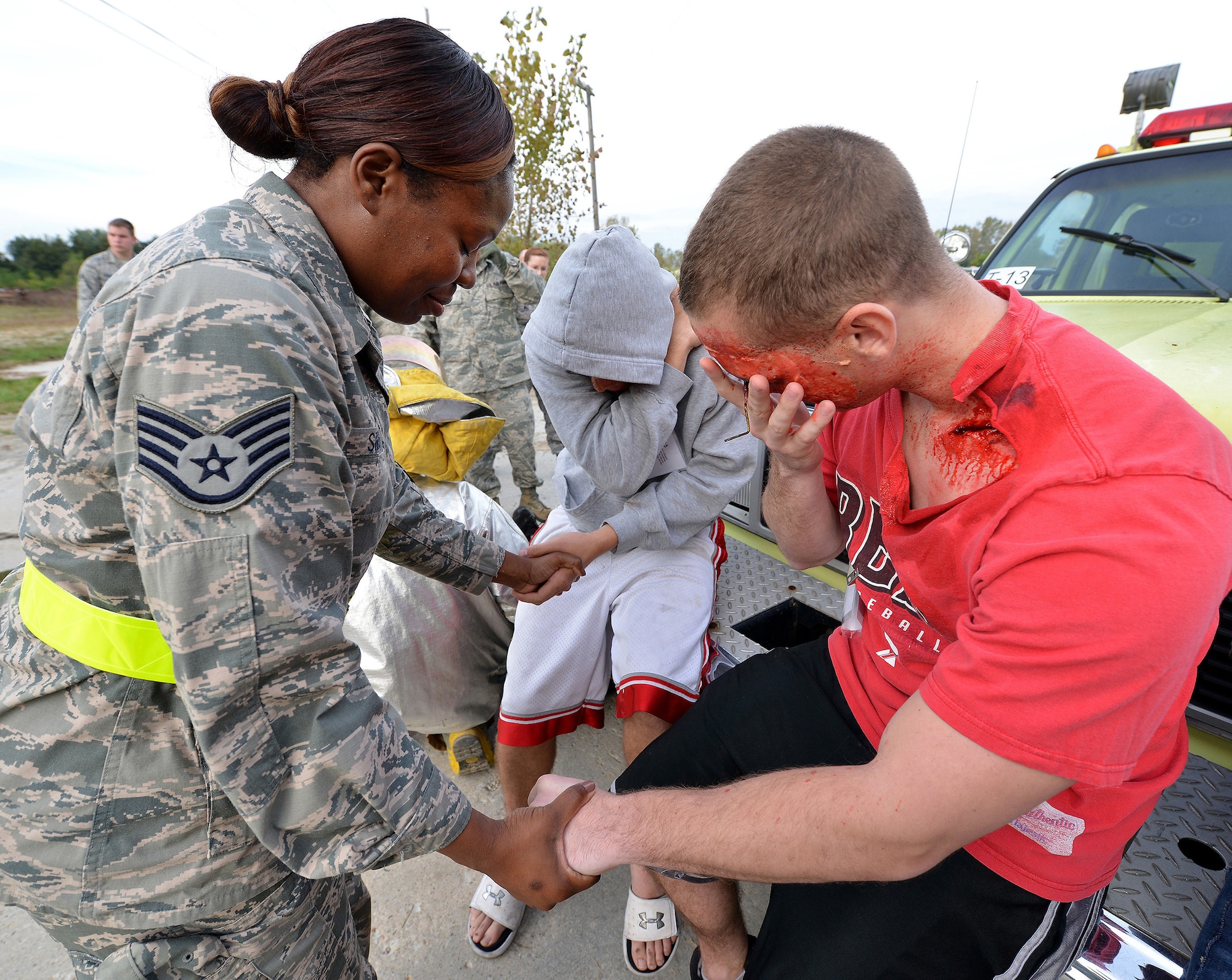 WRIGHT-PATTERSON AIR FORCE BASE, Ohio - Staff Sgt. Precious Sims, 445th Airlift Wing Chaplain Corps chaplain’s assistant, prays with simulated injured men during the wing’s massive disaster response exercise held at Calamityville training and research facility in Fairborn, Ohio, Sept. 29. (U.S. Air Force photo/Tech. Sgt. Frank Oliver)