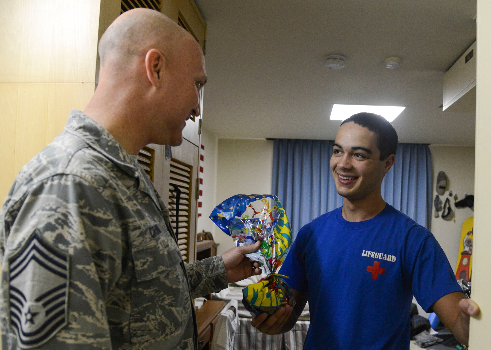 Chief Master Sgt. Kenneth Cronin, 374th Maintenance Squadron superintendent, hands a bag of cookies to an Airman during the 2013 Cookie Crunch at Yokota Air Base, Japan, Dec. 3.  The cookies were hand-baked by the Yokota community, bagged by volunteer workers and distributed by chiefs, first sergeants and designated couriers.  (U.S. Air Force photo by Airman 1st Class Soo C. Kim / Released)