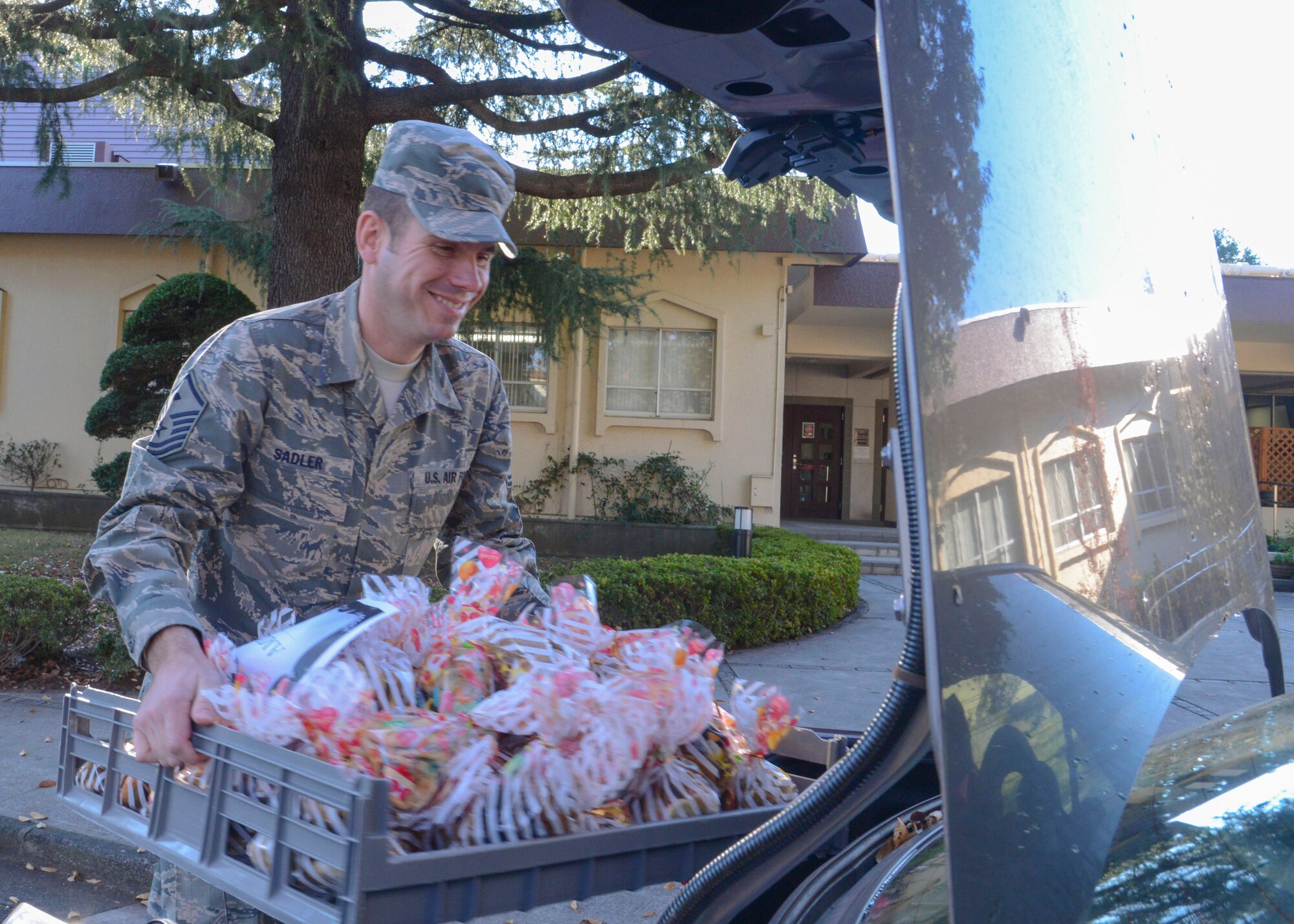 Master Sgt. Douglas Sadler, 374th Aircraft Maintenance Squadron first sergeant, loads a crate full of cookies for the 2013 Cookie Crunch event at Yokota Air Base, Japan, Dec. 3.  The handmade cookies were distributed to unaccompanied service members by the unit’s first sergeants or designated couriers.  (U.S. Air Force photo by Airman 1st Class Soo C. Kim / Released)