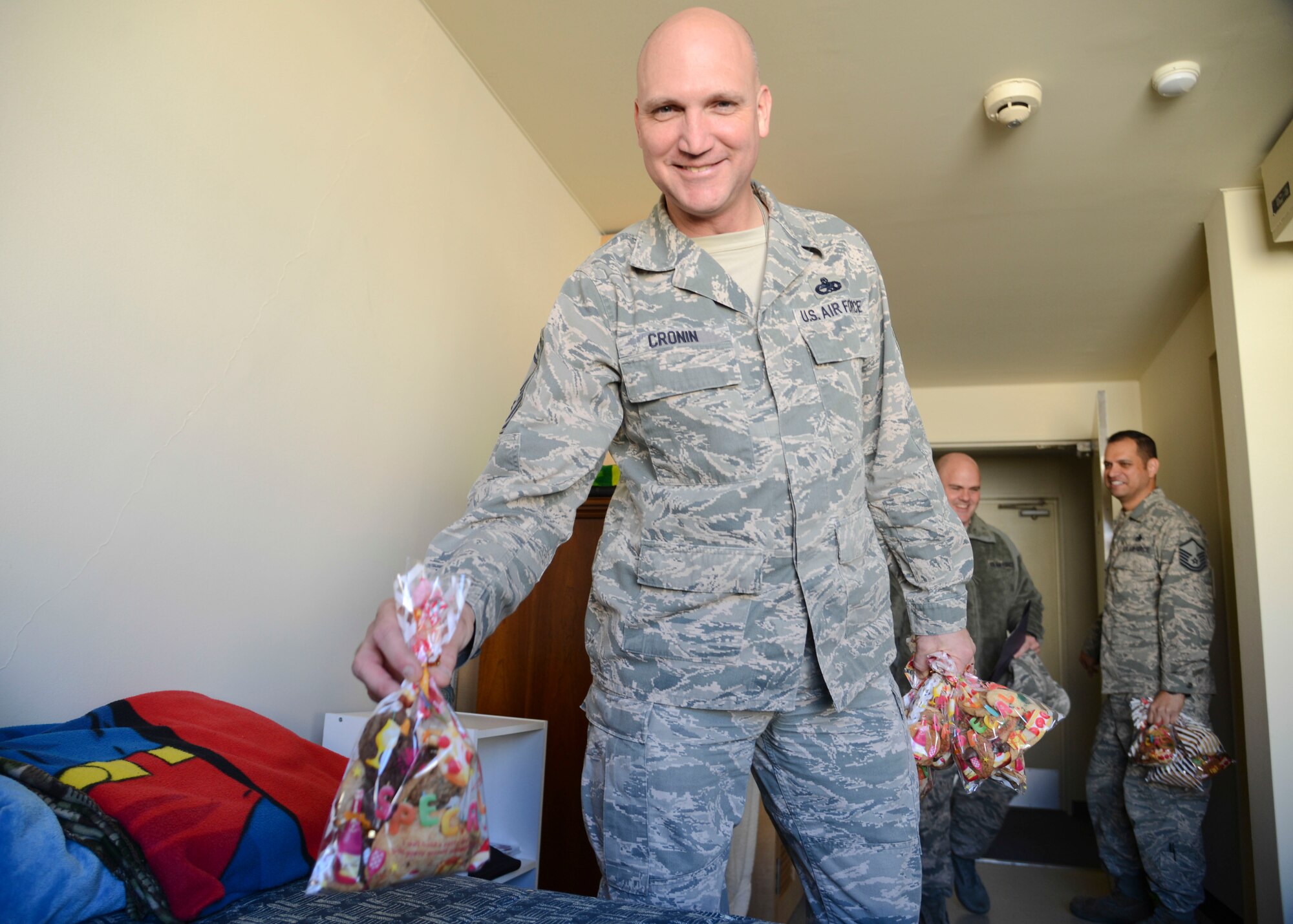 Chief Master Sgt. Kenneth Cronin, 374th Maintenance Squadron superintendent, delivers a bag of cookies for the 2013 Cookie Crunch event at Yokota Air Base, Japan, Dec. 3.  The Cookie Crunch event delivers holiday spirit to those unable to see their family during the holiday season.  (U.S. Air Force photo by Airman 1st Class Soo C. Kim / Released)