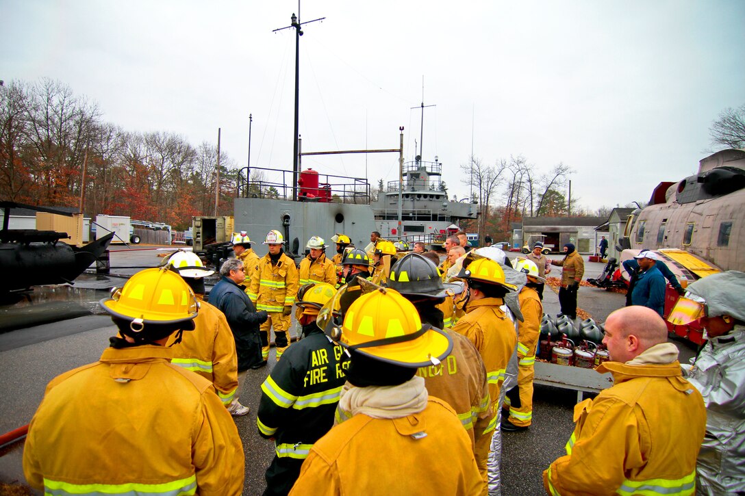 A Military Sealift Command fire training instructor briefs airmen on