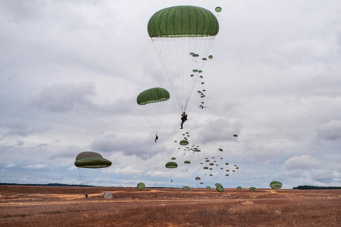 Paratroopers descend on Sicily Drop Zone during the 16th Annual Randy Oler Memorial Operation Toy Drop on Fort Bragg, N.C., Dec. 7, 2013.
