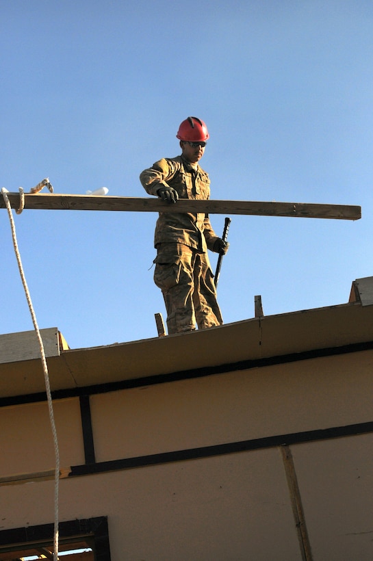 U.S. Army Pfc. Joseph Bove moves a beam while deconstructing a building on Kandahar Airfield in Kandahar province, Afghanistan, Nov. 27, 2013. Bove, a combat engineer, is assigned to the 760th Engineer Company, 489th Engineer Battalion, which is attached to the 82nd Sustainment Brigade, U.S. Central Command Materiel Recovery Element.