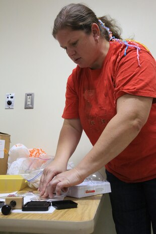 Brenda Piper, an ornament class participant, presses a Kanji stamp on a tag as one of the final touches of her ornament during the ornament class, Dec. 5, 2013, at Building 655 aboard Marine Corps Air Station Iwakuni, Japan. Piper said this crafting class was a good event for people who have little to no experience. 