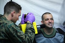 Seaman Matthew N. McRimmon (left), a dental techician with  2nd Dental Battalion, 2nd Marine Logistics Group, takes x-rays of Senior Chief Petty Officer Joseph Speranza’s teeth during an Authorized Dental Allowance List exercise aboard Camp Lejeune, N.C., Dec. 6, 2013.  The exercise gave sailors with 2nd Dental Bn. the chance to get hands on with expeditionary equipment and prepared them for future deployments. (U.S. Marine Corps photo by Lance Cpl. Shawn Valosin)