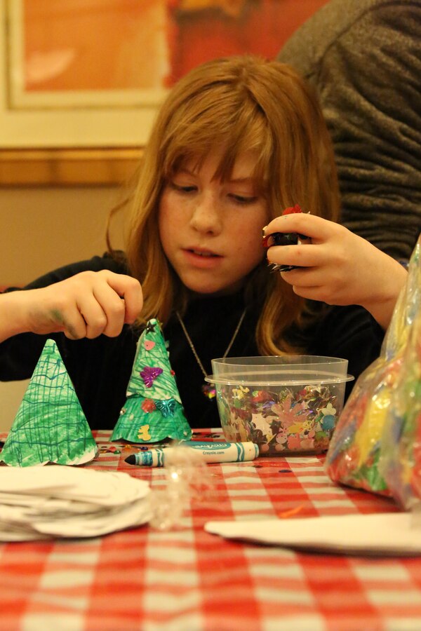 A participant makes a craft during the EFMP holiday event at the Lincoln Military Housing main office Dec. 6, 2013. Children made Christmas stockings as one of the crafts. 