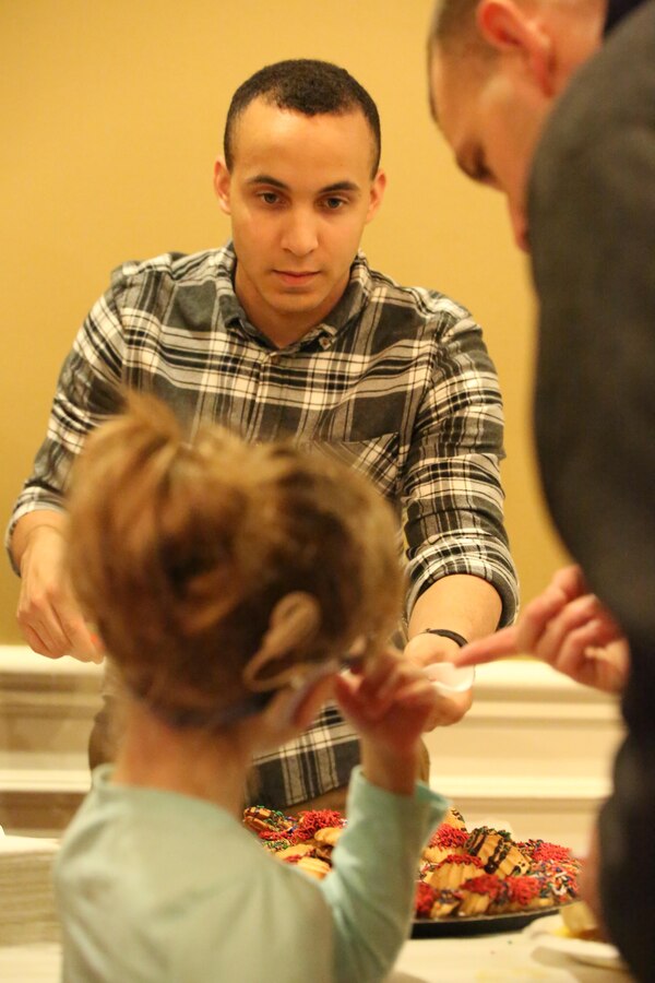 Lance Cpl. Francisco Martinez, volunteer, serves dinner during the EFMP holiday event at the Lincoln Military Housing main office Dec. 6, 2013. More than 100 people attended the annual event. 