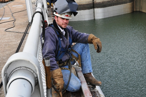 Craig Smith, Nashville District Tennessee River Operations Center, takes a momentary break from welding plates securing new tow haulage rail on Kentucky Lock wall Nov. 5, 2013. Nashville District employees completed the Tow Haulage Unit Replacement Project on time at Kentucky Lock in Grand Rivers, Ky., Dec. 5, 2013, and the lock has resumed 24-hour operations. The new unit should move unpowered tows more efficiently and also eliminate a winter icing problem caused by the design of the 69-year-old tow haulage unit installed in 1944, according to Jeff Ross, Nashville District navigation chief.