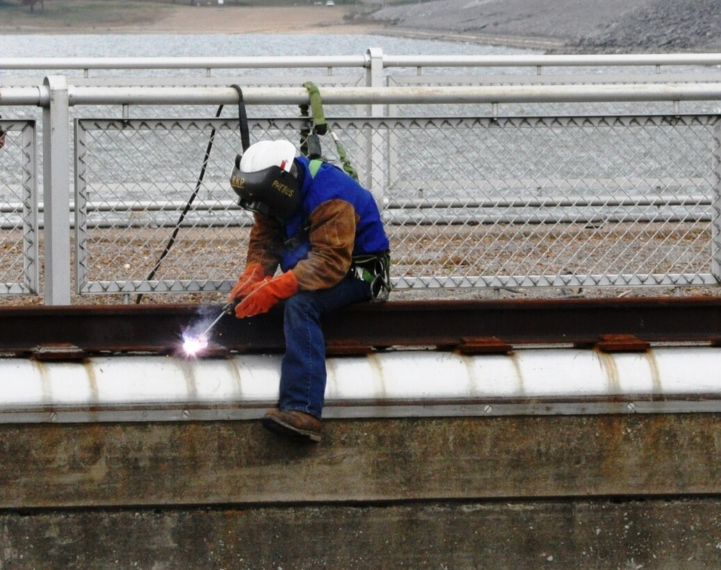 Kevin Phebus, Nashville District Tennessee River Operations Center, welds plates securing a new tow haulage rail on Kentucky Lock wall Nov. 5, 2013. Nashville District employees completed the Tow Haulage Unit Replacement Project on time at Kentucky Lock in Grand Rivers, Ky., Dec. 5, 2013, and the lock has resumed 24-hour operations. The new unit should move unpowered tows more efficiently and also eliminate a winter icing problem caused by the design of the 69-year-old tow haulage unit installed in 1944, according to Jeff Ross, Nashville District navigation chief.